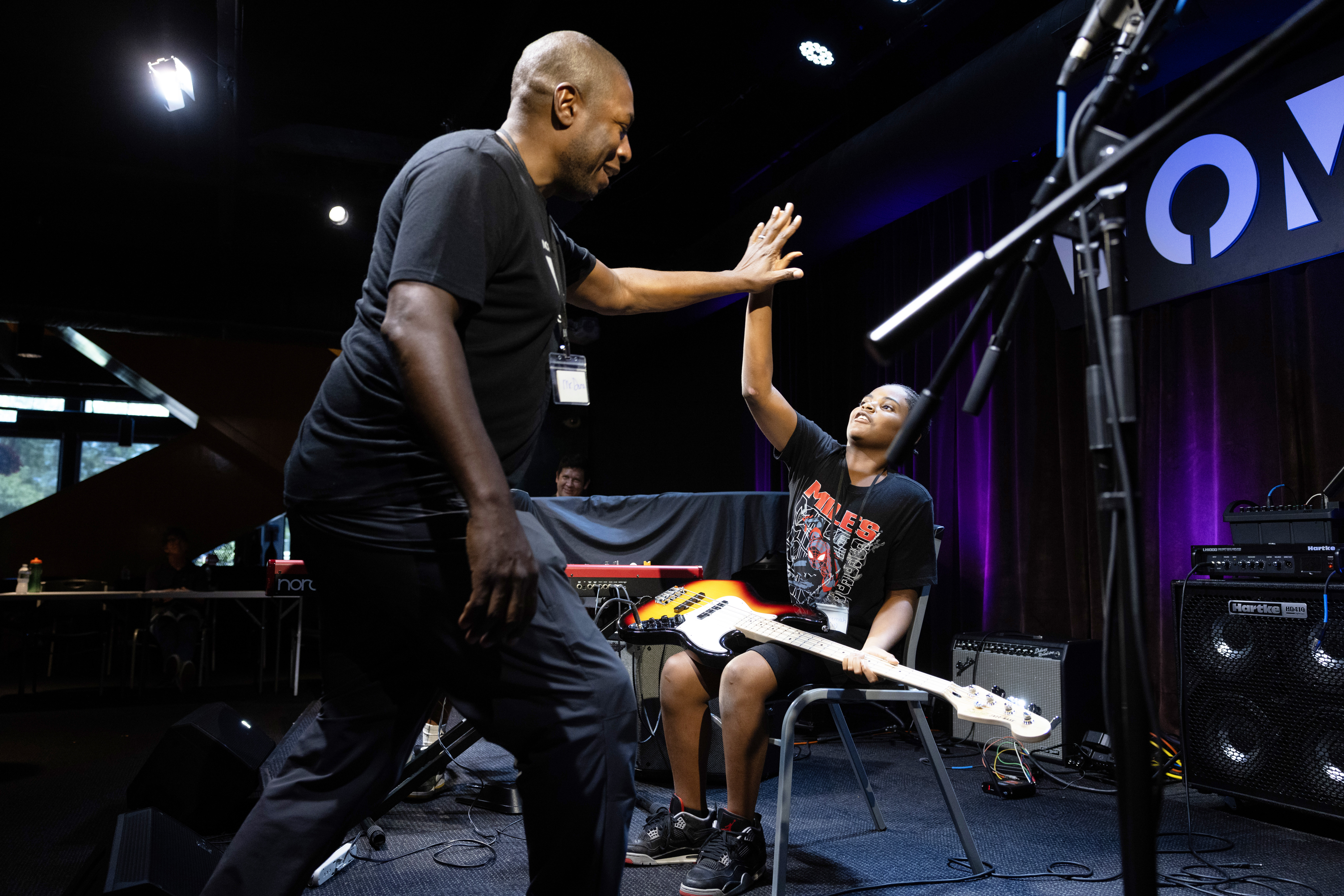 Dana Murray, executive director of North Omaha Music &amp; Arts, high fives Jeremiah Roseby, 10, during a summer music camp in Omaha.<br />(Rebecca S. Gratz / Flatwater Free Press)