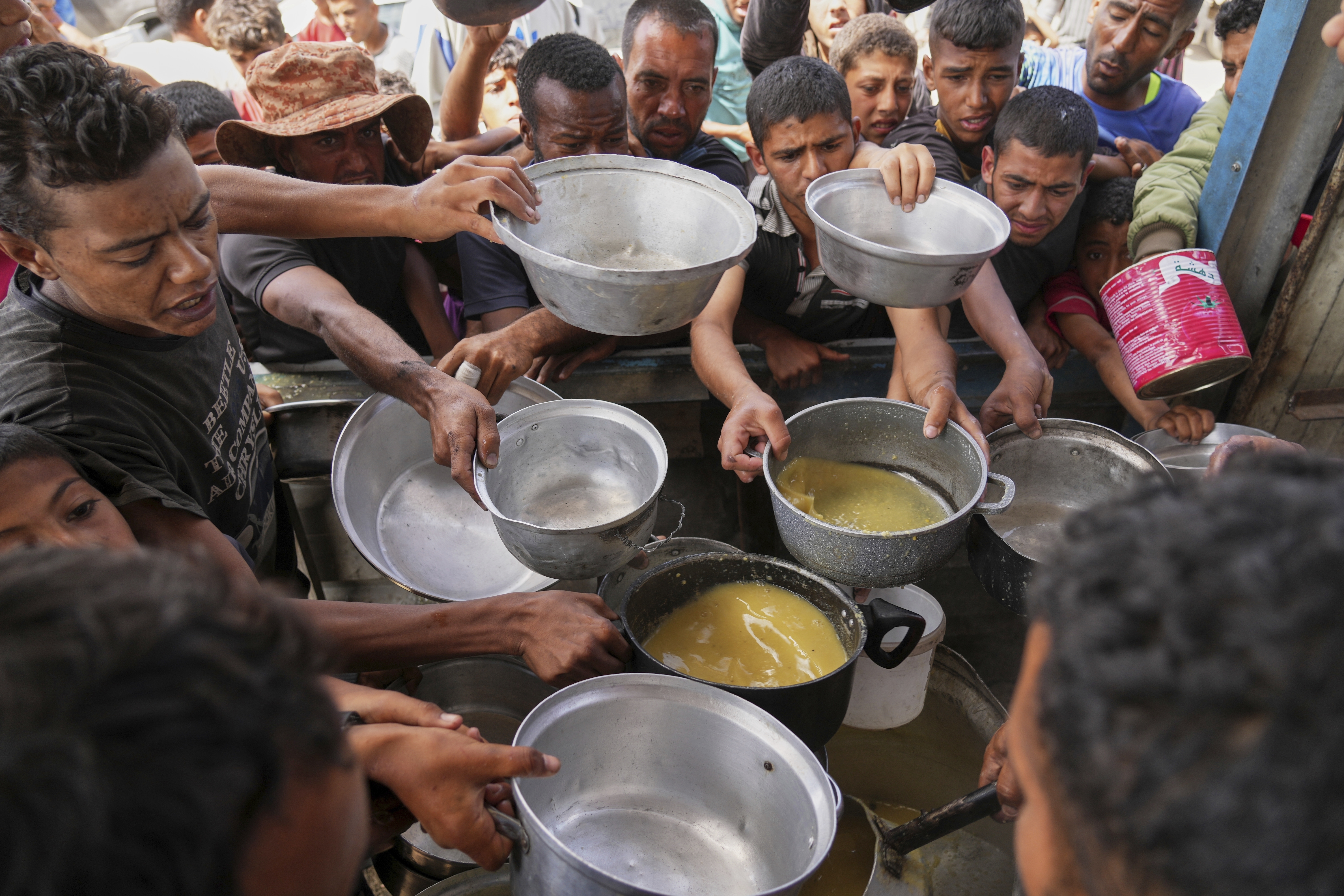 Palestinians struggle to receive cooked food distributed at a community kitchen in Khan Younis, southern Gaza Strip, Wednesday, May 14, 2025.<br />(Abdel Kareem Hana / AP Photo)