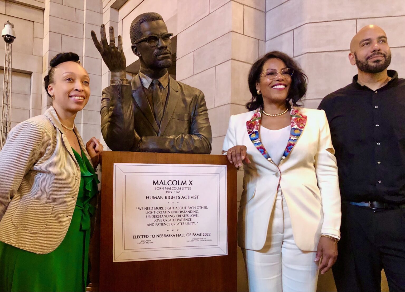 A bust sculpture of Malcolm X was unveiled at his May 2024 induction into the Nebraska Hall of Fame. The art was designed by Lincoln artist Nathan Murray, who is shown here with Malcolm X’s daughter Ilyasah Shabazz (right of the bust) and JoAnna LeFlore-Ejike, executive director of the Malcolm X Memorial Foundation. The bust’s permanent spot is in a hallway of the State Capitol with other Hall of Fame busts.<br /> (Cindy Gonzalez / Nebraska Examiner)