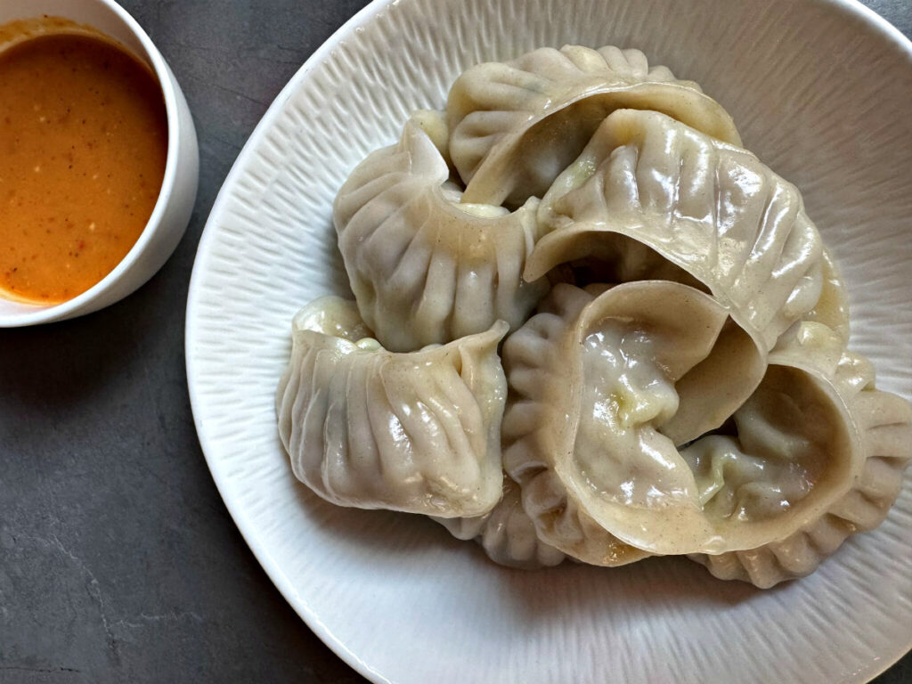 Many diners will recognize the momos, which are also on the menu at the restaurant’s sister concept, Kathmandu Momo Station. The chicken variety here is served with a side of the spicy sherpa sauce.<br />(Sarah Baker Hansen / Flatwater Free Press)