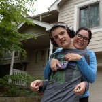 Teddy Gleason leans into a hug with his mother Angela outside their northwest Omaha home on Friday, May 23, 2025. Teddy, 13, will start eighth grade at Omaha’s Davis Middle School in the fall. 
(Liz McCue / Flatwater Free Press)