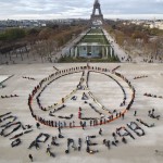 Environmentalist activists form a human chain representing the peace sign and the spelling out "100% Renewable", on the side line of the COP21, United Nations Climate Change Conference near the Eiffel Tower in Paris on Dec. 6, 2015. 
(Michel Euler / AP Photo)