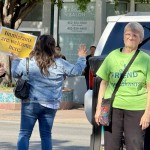 Rallygoers wave at passing cars that honk and give thumbs up to the “Stand in Solidarity” event Thursday afternoon in South Omaha.
(Cindy Gonzalez / Nebraska Examiner)
