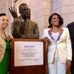 A bust sculpture of Malcolm X was unveiled at his May 2024 induction into the Nebraska Hall of Fame. The art was designed by Lincoln artist Nathan Murray, who is shown here with Malcolm X’s daughter Ilyasah Shabazz (right of the bust) and JoAnna LeFlore-Ejike, executive director of the Malcolm X Memorial Foundation. The bust’s permanent spot is in a hallway of the State Capitol with other Hall of Fame busts.
 (Cindy Gonzalez / Nebraska Examiner)