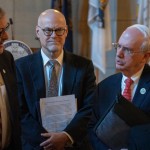 University of Nebraska Dr. Jeffrey Gold (right) speaks with state senators and NU regents after a forum with dozens of Nebraska state senators regarding NU’s proposal to buy out the share of Nebraska Medicine owned by Clarkson Regional Health Services. (At center) is Dr. Bill Lydiatt, Clarkson’s CEO, and (at left) is State Sen. Mike Jacobson of North Platte, Jan. 14, 2026. (Zach Wendling / Nebraska Examiner)
