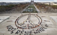 Environmentalist activists form a human chain representing the peace sign and the spelling out "100% Renewable", on the side line of the COP21, United Nations Climate Change Conference near the Eiffel Tower in Paris on Dec. 6, 2015. 
(Michel Euler / AP Photo)
