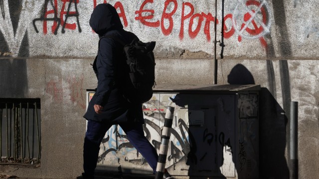 A woman passes by a graffiti reading "No to the euro" altered to "Yes to the euro" in Sofia, Monday, Dec. 29, 2025. 
(Valentina Petrova / AP Photo)