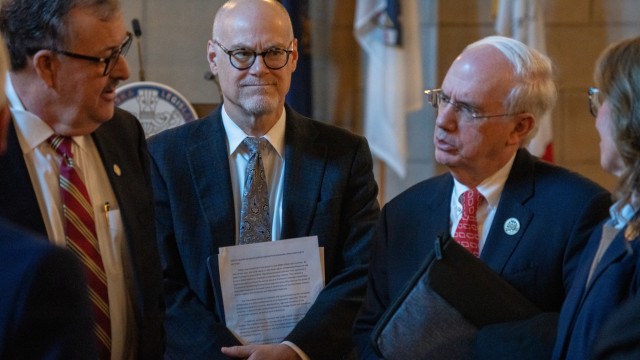 University of Nebraska Dr. Jeffrey Gold (right) speaks with state senators and NU regents after a forum with dozens of Nebraska state senators regarding NU’s proposal to buy out the share of Nebraska Medicine owned by Clarkson Regional Health Services. (At center) is Dr. Bill Lydiatt, Clarkson’s CEO, and (at left) is State Sen. Mike Jacobson of North Platte, Jan. 14, 2026. (Zach Wendling / Nebraska Examiner)