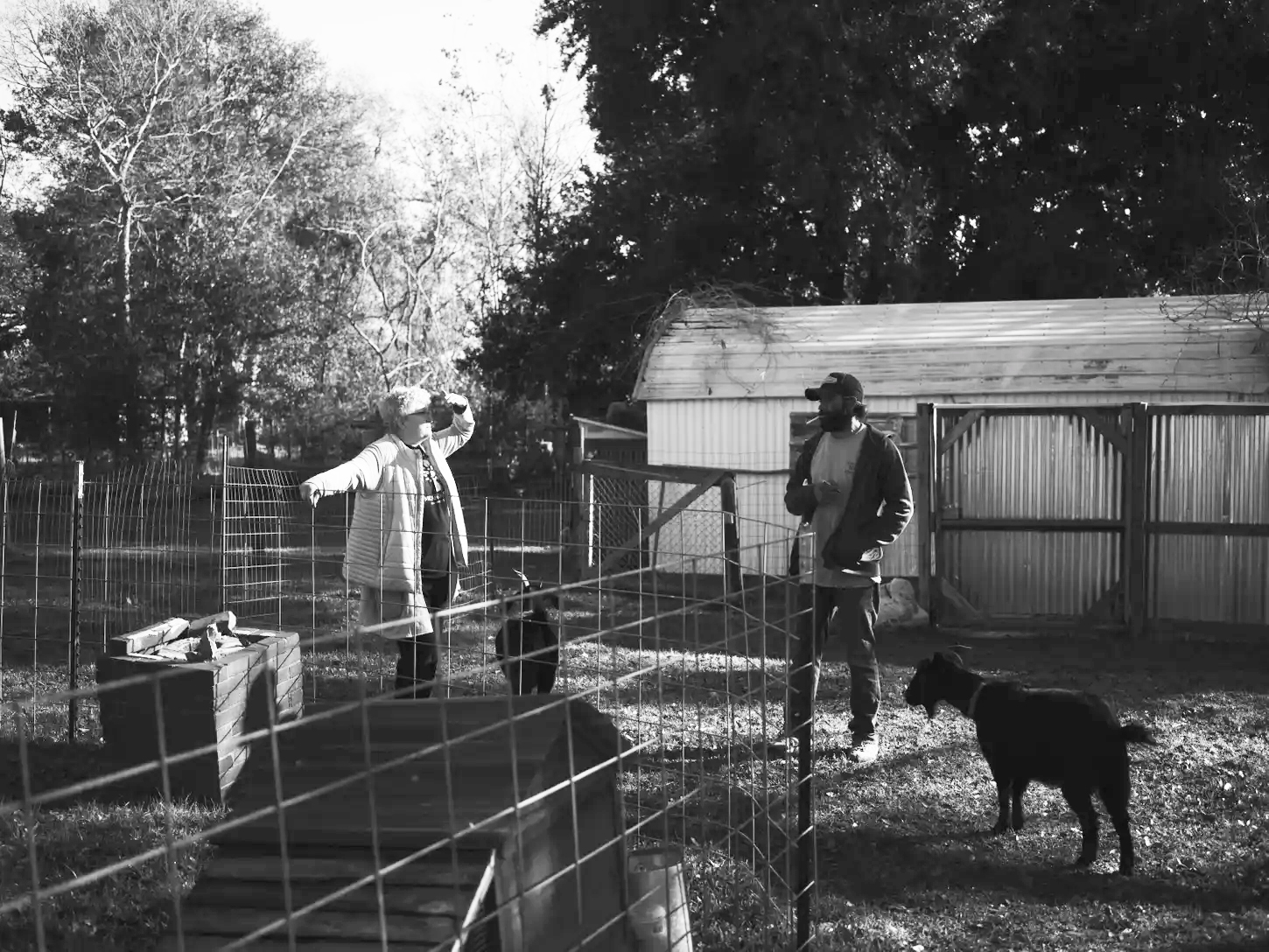 Cynthia Robertson and her neighbor, Nate, at home with her goats in Portie Town. Robertson is seeking funding through President Joe Biden’s signature climate law so her nonprofit organization can repair and retrofit hurricane-battered houses in the area.<br />(Annie Flanagan / ProPublica)