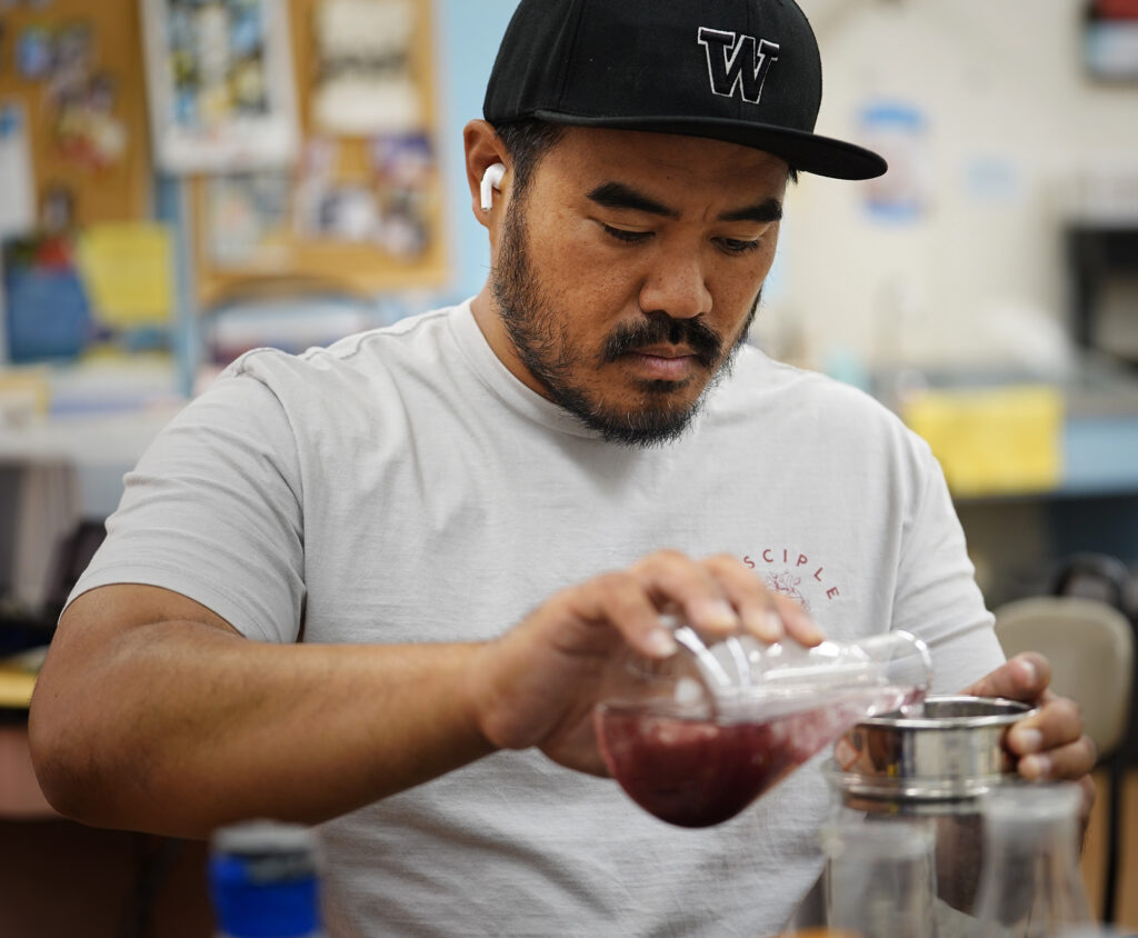 Career Technical Education teacher Tyson Arasato, a 2007 Waiʻanae High School graduate, changes the water for young limu kohu as part of research with Big Island business Symbrosia.<br /> (Kevin Fujii / Civil Beat)