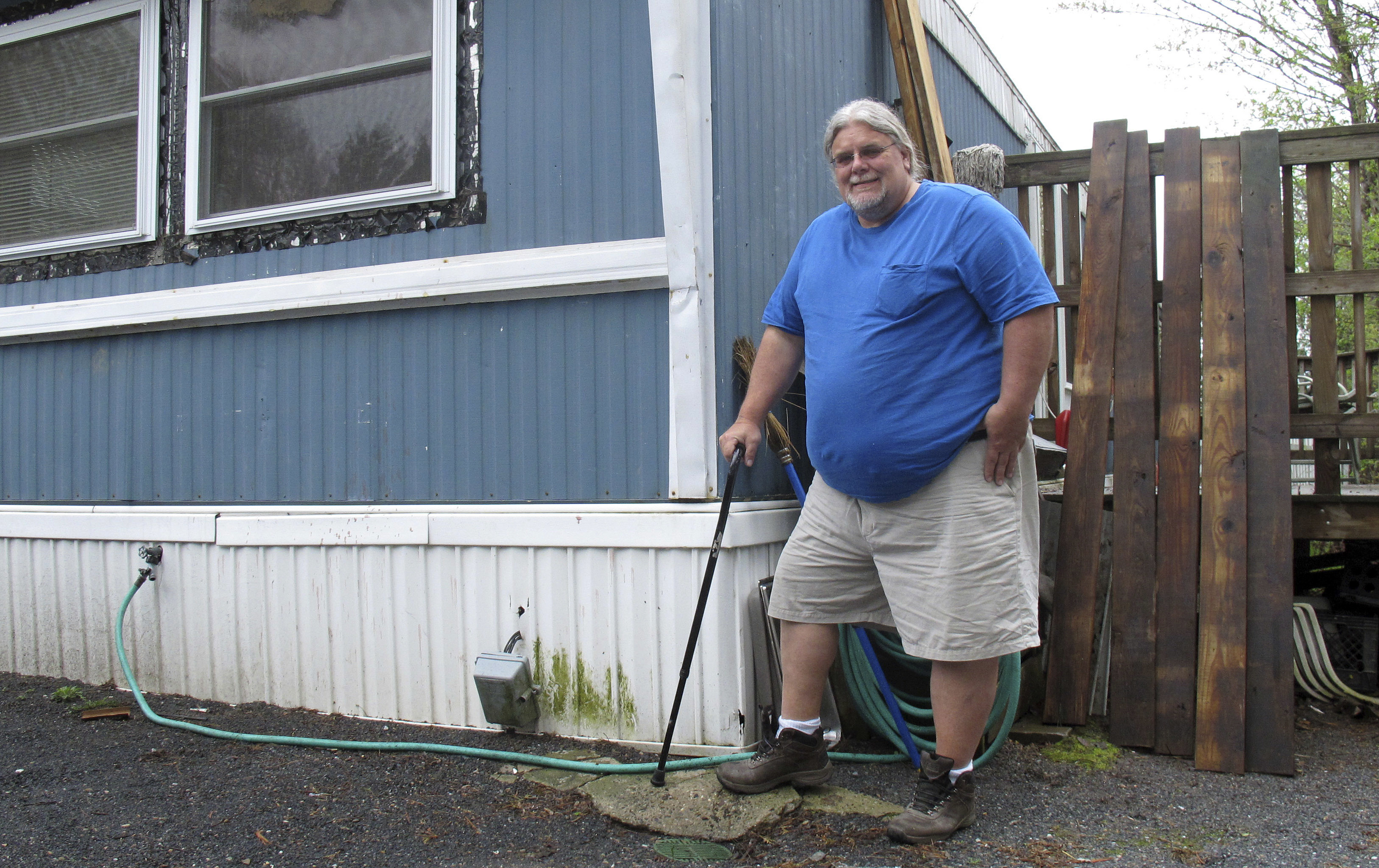 Todd Alexander poses at his mobile home in Milton, Vt., that he heats with the help of the Low Income Heating Home Energy Assistance Program. Alexander, who is disabled and living on disability, said the assistance has helped him meet his energy needs and still have money left over to live.<br /> (Wilson Ring / AP Photo)
