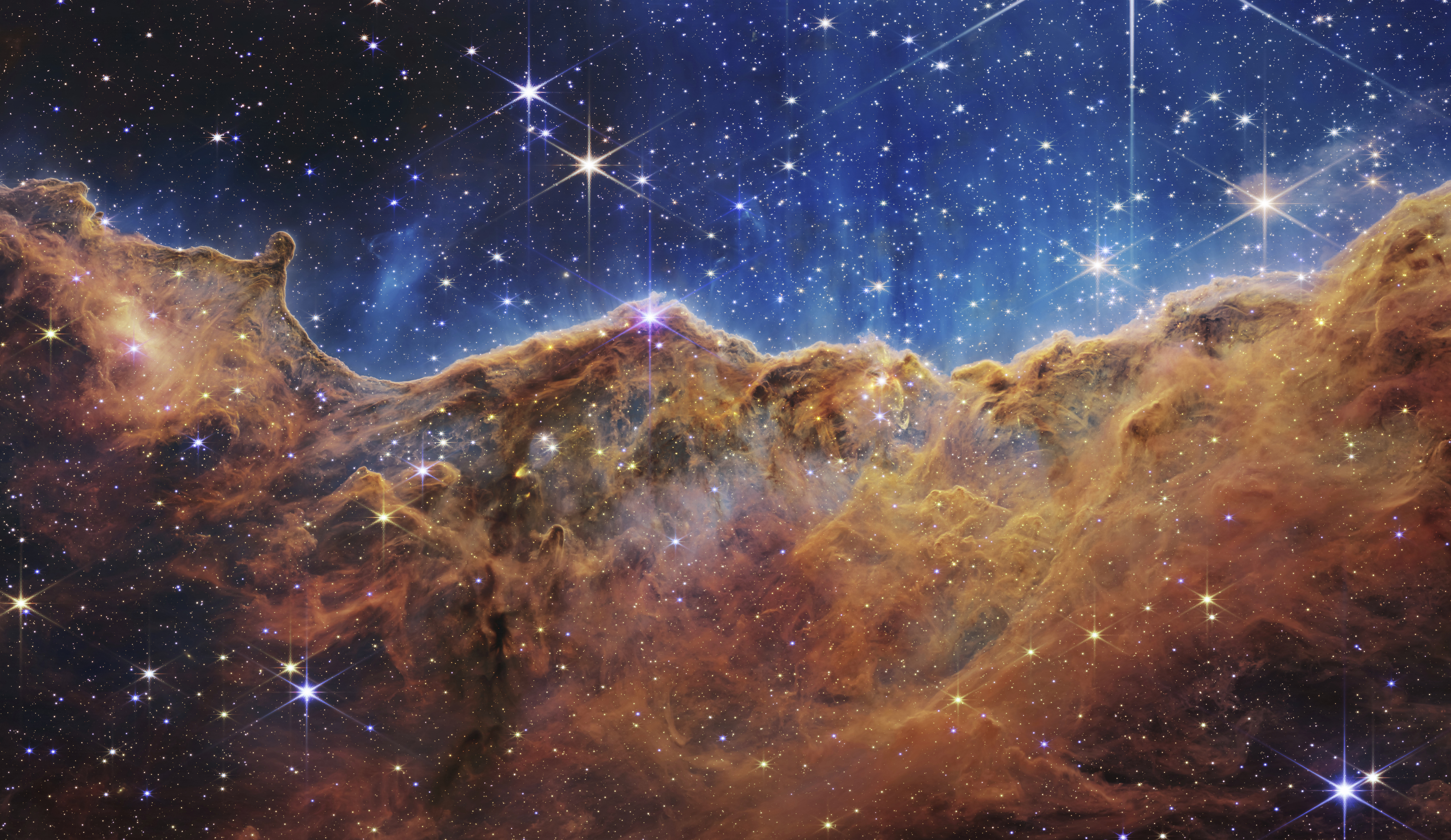 This image released by NASA on Tuesday, July 12, 2022, shows the edge of a nearby, young, star-forming region NGC 3324 in the Carina Nebula. (NASA, ESA, CSA, and STScI via AP)