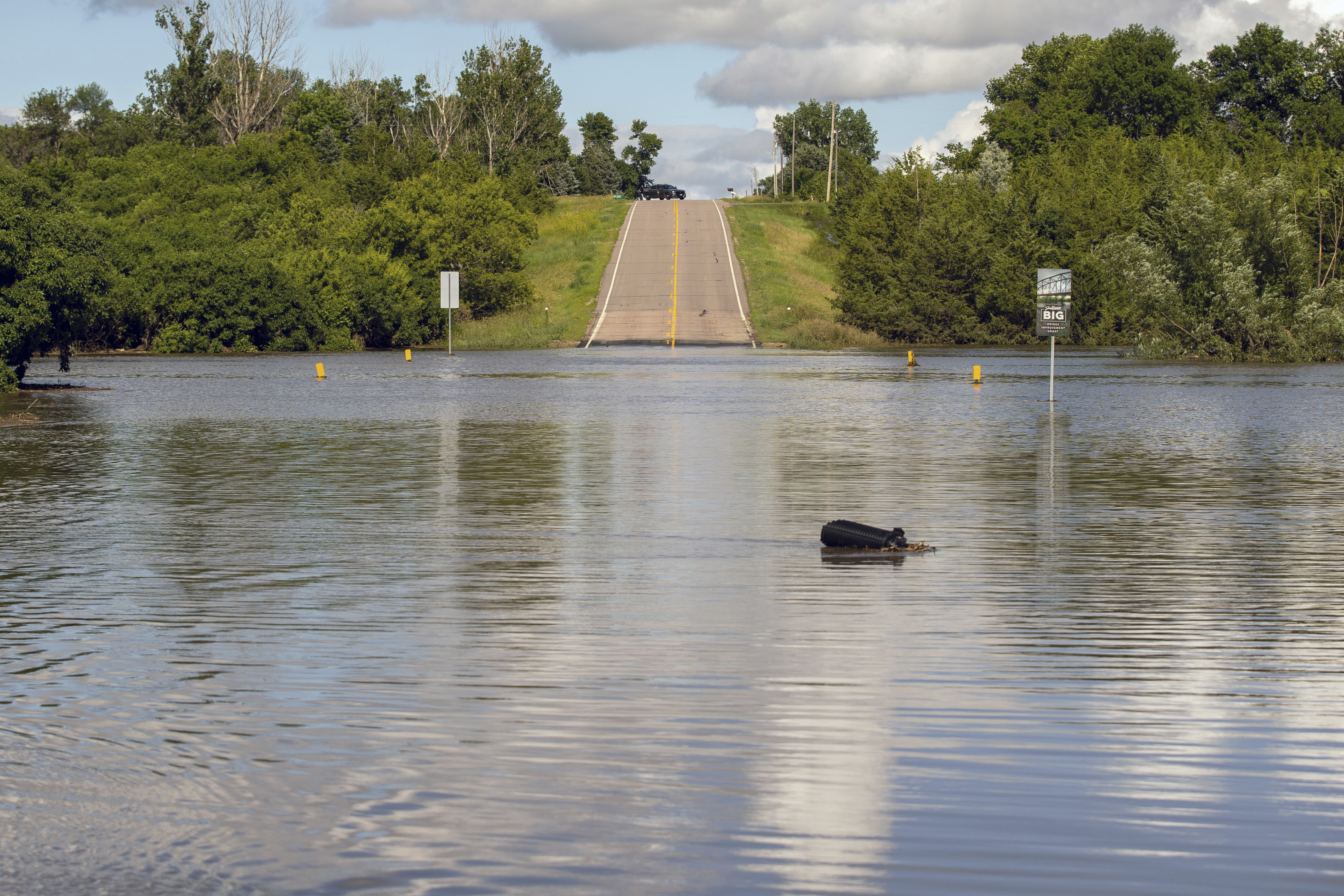 A South Dakota Highway Patrol Officer keeps watch over a flooded bridge that was underwater after days of heavy rain led to flooding in the area, near Lake Alvin, S.D., Saturday, June 22, 2024.<br />(Josh Jurgens / AP Photo)