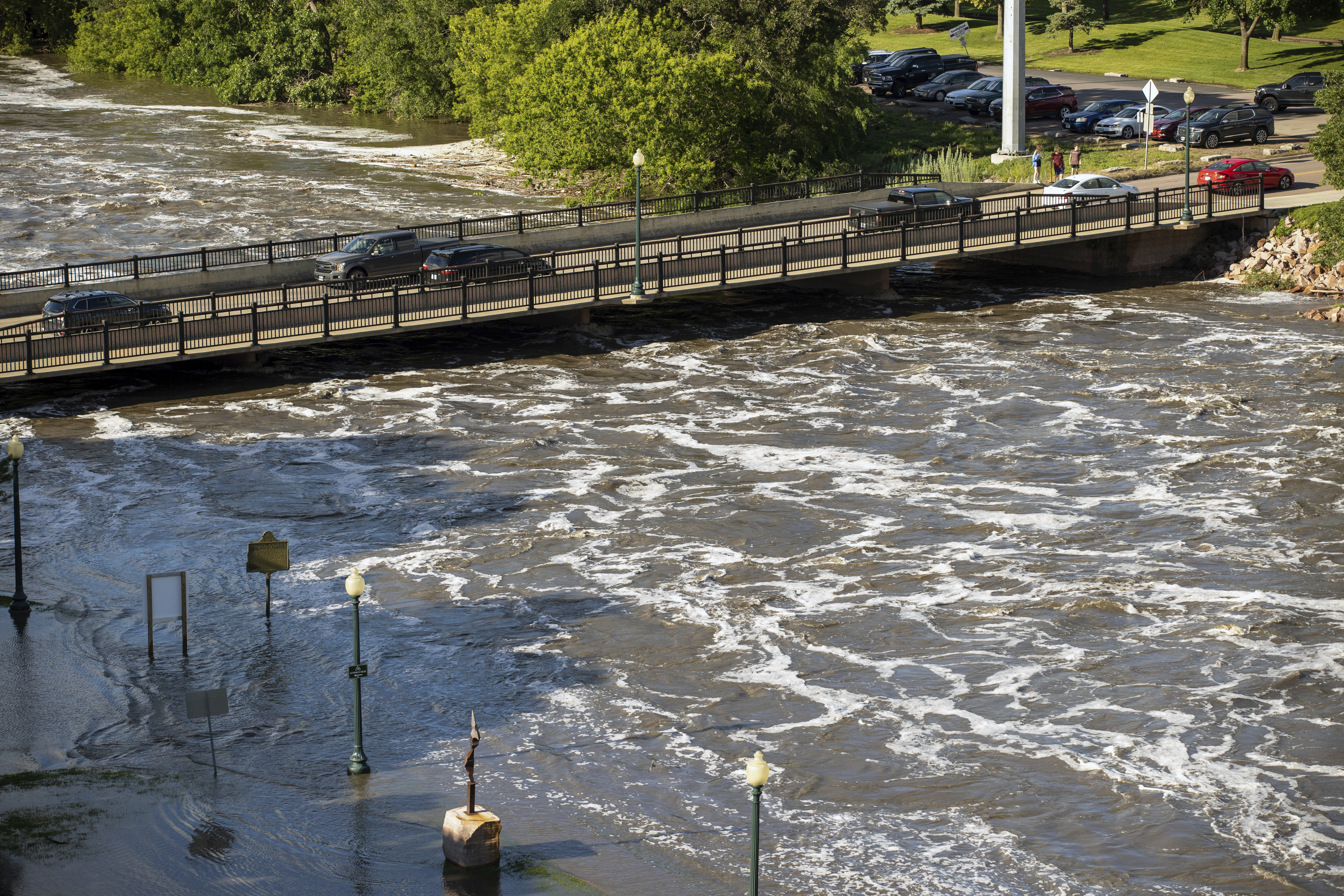 Water flow dangerously under the Falls Park Dr bridge at Falls Park in Sioux Falls, S.D., Saturday, June 22, 2024.<br />(Josh Jurgens / AP Photo)