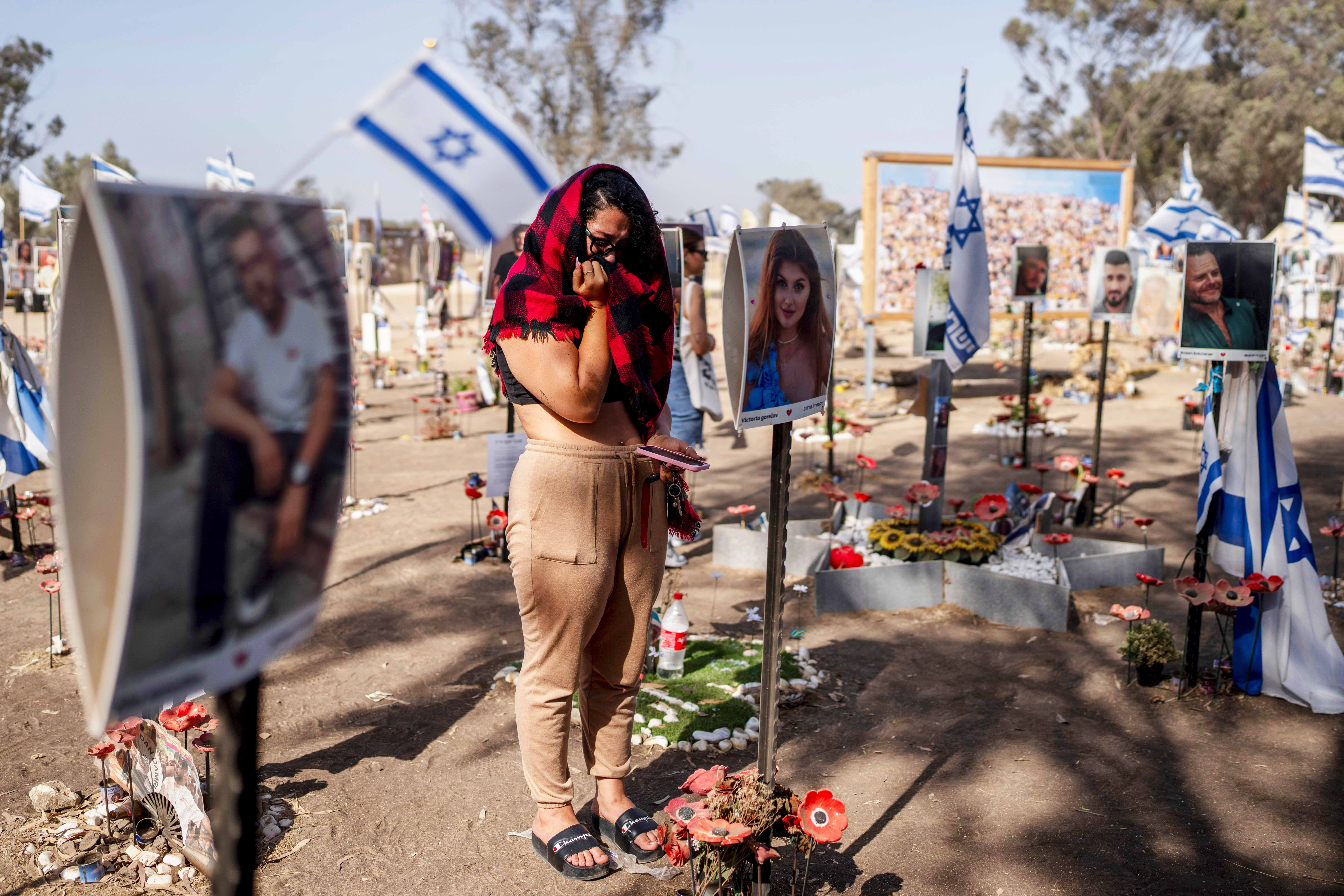 A woman stands next to photos of people killed and taken captive by Hamas militants during their violent rampage through the Nova music festival in southern Israel, which are displayed at the site of the event to commemorate the Oct. 7, massacre near Kibbutz Re&#039;im on Thursday, June 20, 2024.<br />(Oded Balilty / AP Photo)