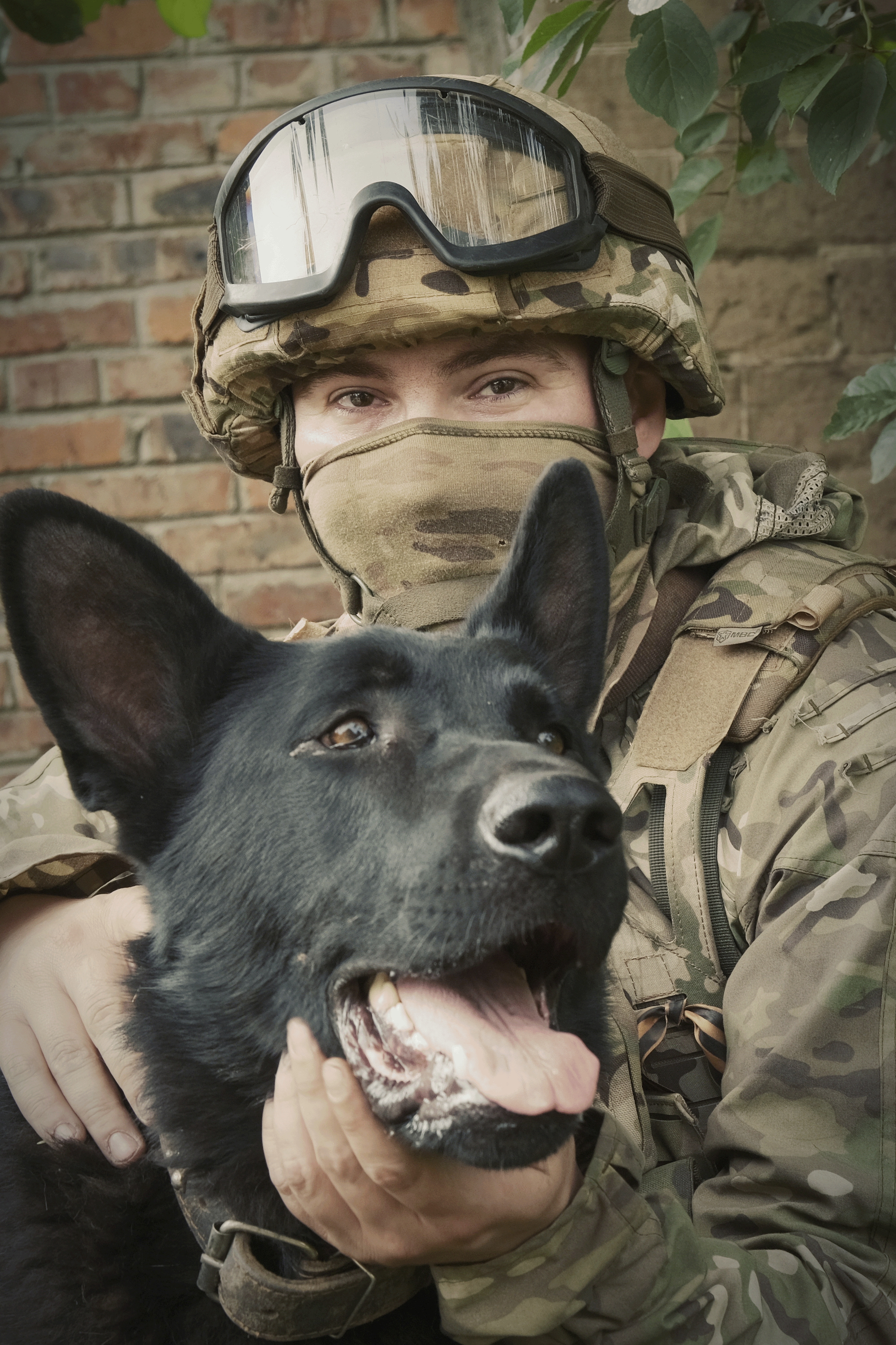 In this photo released by the Russian Defense Ministry Press Service on Tuesday, June 25, 2024, a Russian soldier poses for photo with his dog in a shelter at a position in an undisclosed location in Ukraine.<br />(Russian Defense Ministry Press Service via AP)