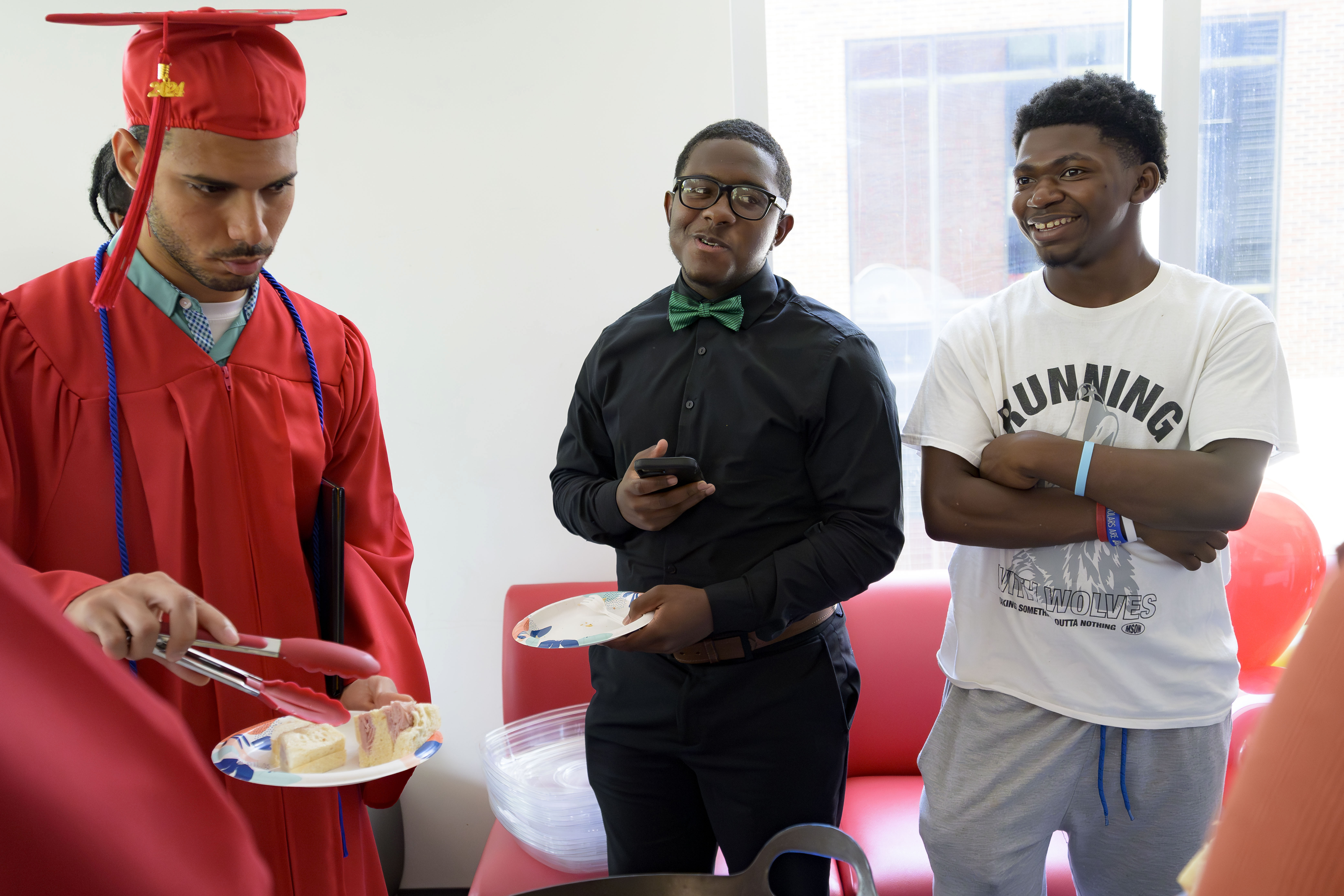 Ke&#039;Daryl Sentmore, 17 (right) is a participant in the Youth Empowerment Project (YEP) works program along with Makhi Trumble, 16 (center) and they both helped out with food at a graduation of fellow students including Darel Godinez Rodriguez (left) in New Orleans, Thursday, June 27, 2024.<br />(Matthew Hinton / AP Photo)