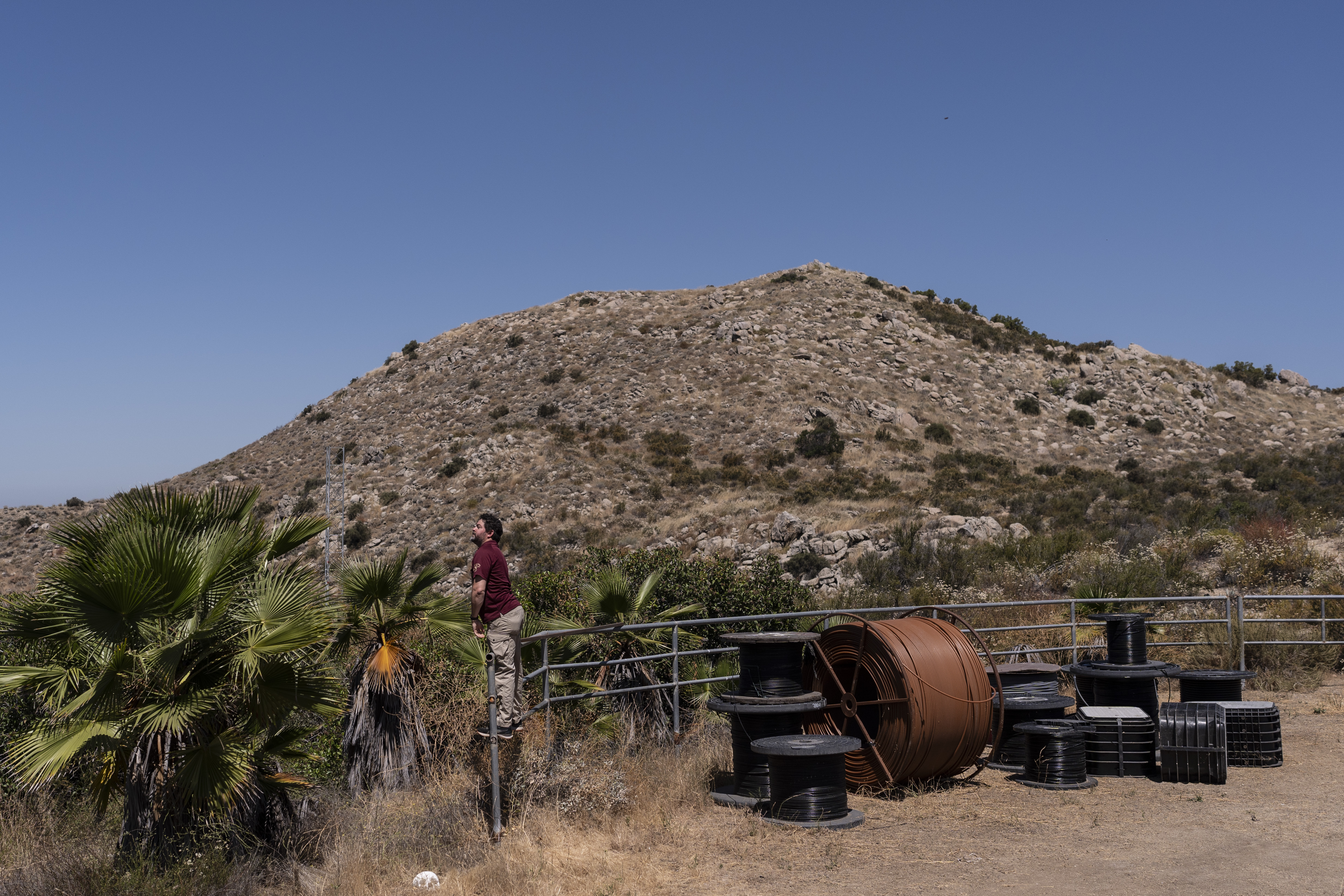 Christopher Mitchell, director of the Community Broadband Networks Initiative, stands on a rail next to spools of cables during the Tribal Broadband Bootcamp in Aguanga, Calif., Wednesday, June 19, 2024.<br />(Jae C. Hong / AP Photo)