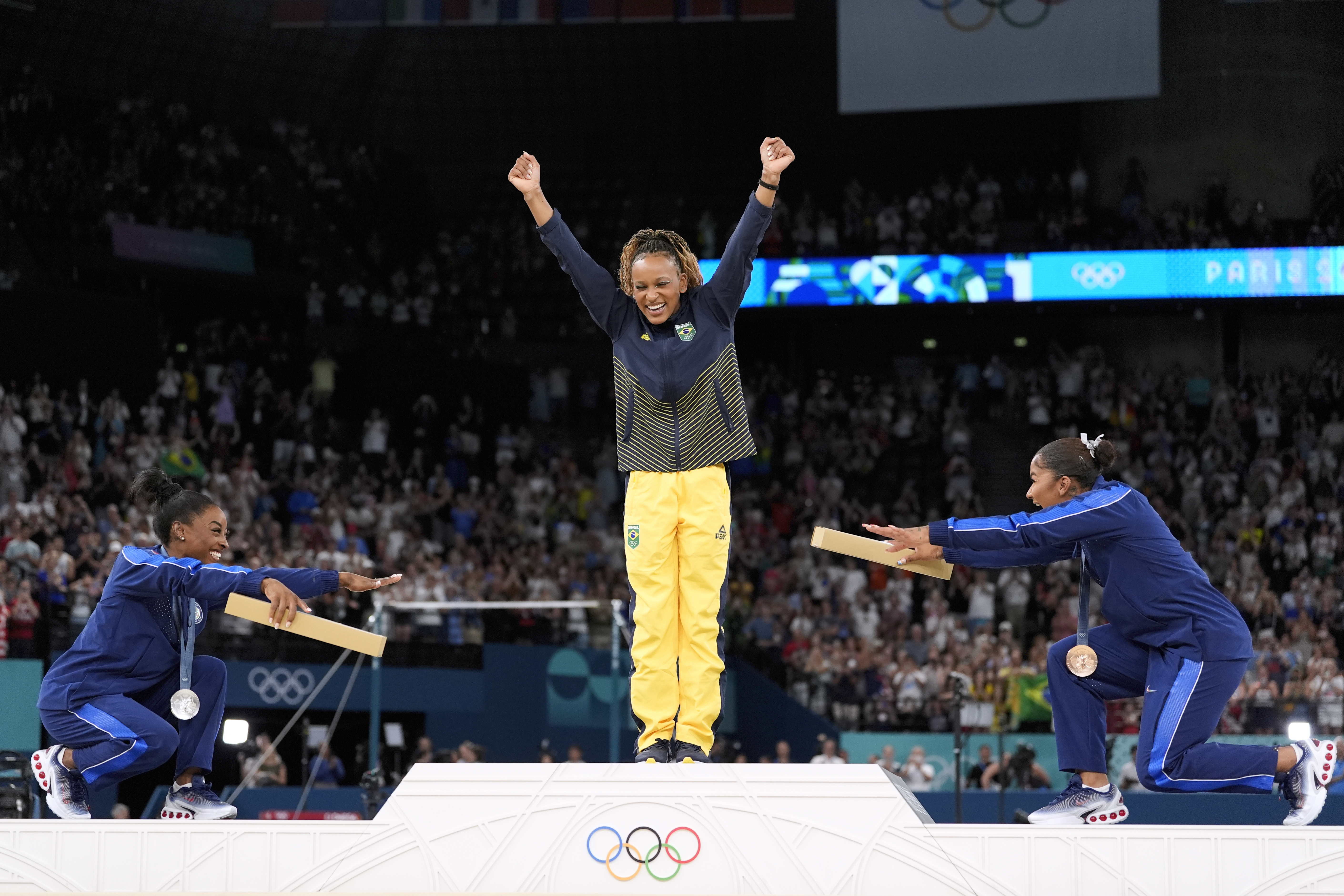 Silver medalist Simone Biles, of the United States, left, and bronze medalist Jordan Chiles, of the United States, right, bow to gold medalist Rebeca Andrade, of Brazil, during the medal ceremony for the women&#039;s artistic gymnastics individual floor finals at Bercy Arena at the 2024 Summer Olympics, Monday, Aug. 5, 2024, in Paris, France.<br />(Abbie Parr / AP Photo