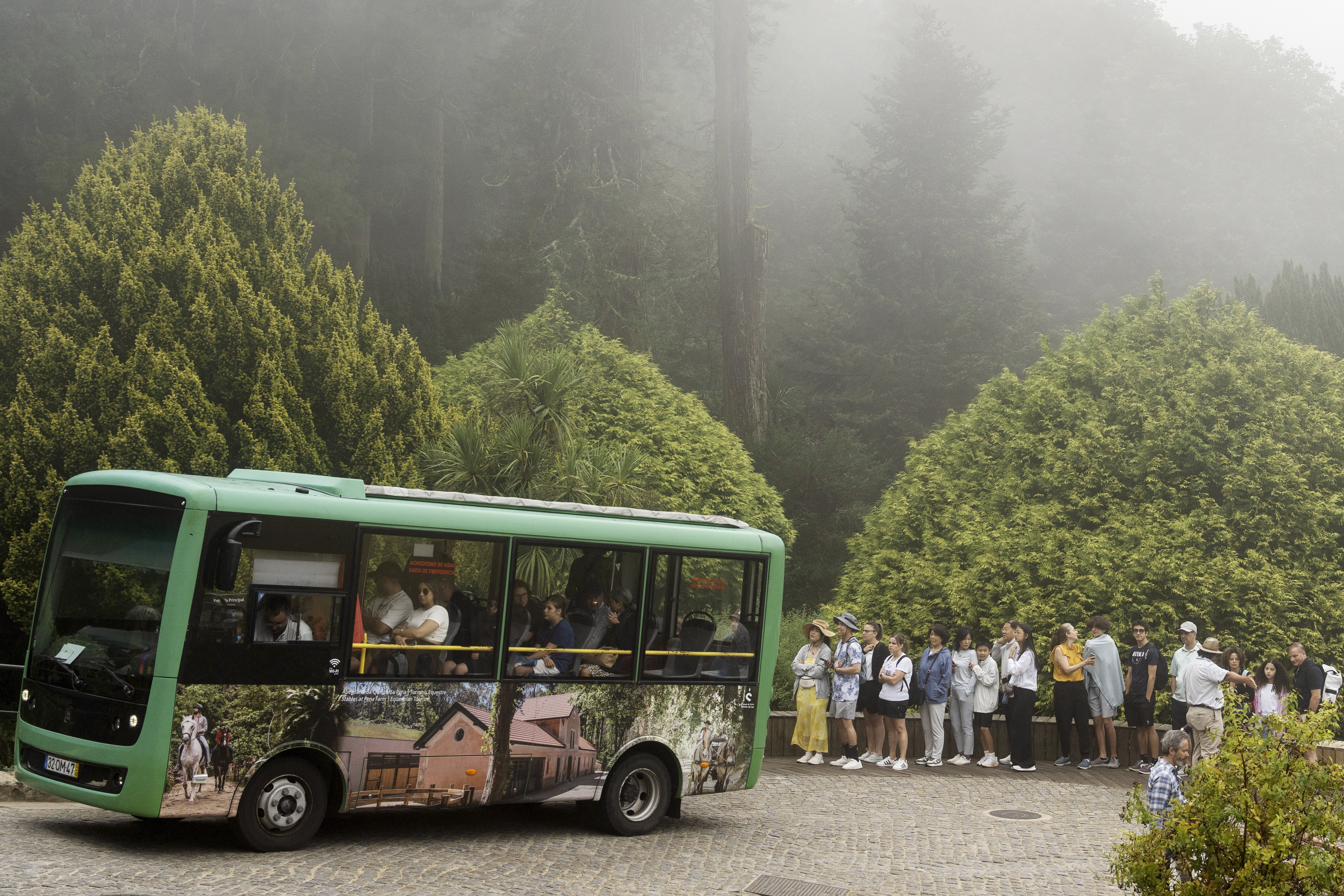 Tourists queue to catch a shuttle bus from the gate up to the 19th century Pena Palace, in Sintra, Portugal, Wednesday, Aug. 14, 2024.<br />(Ana Brigida / AP Photo)
