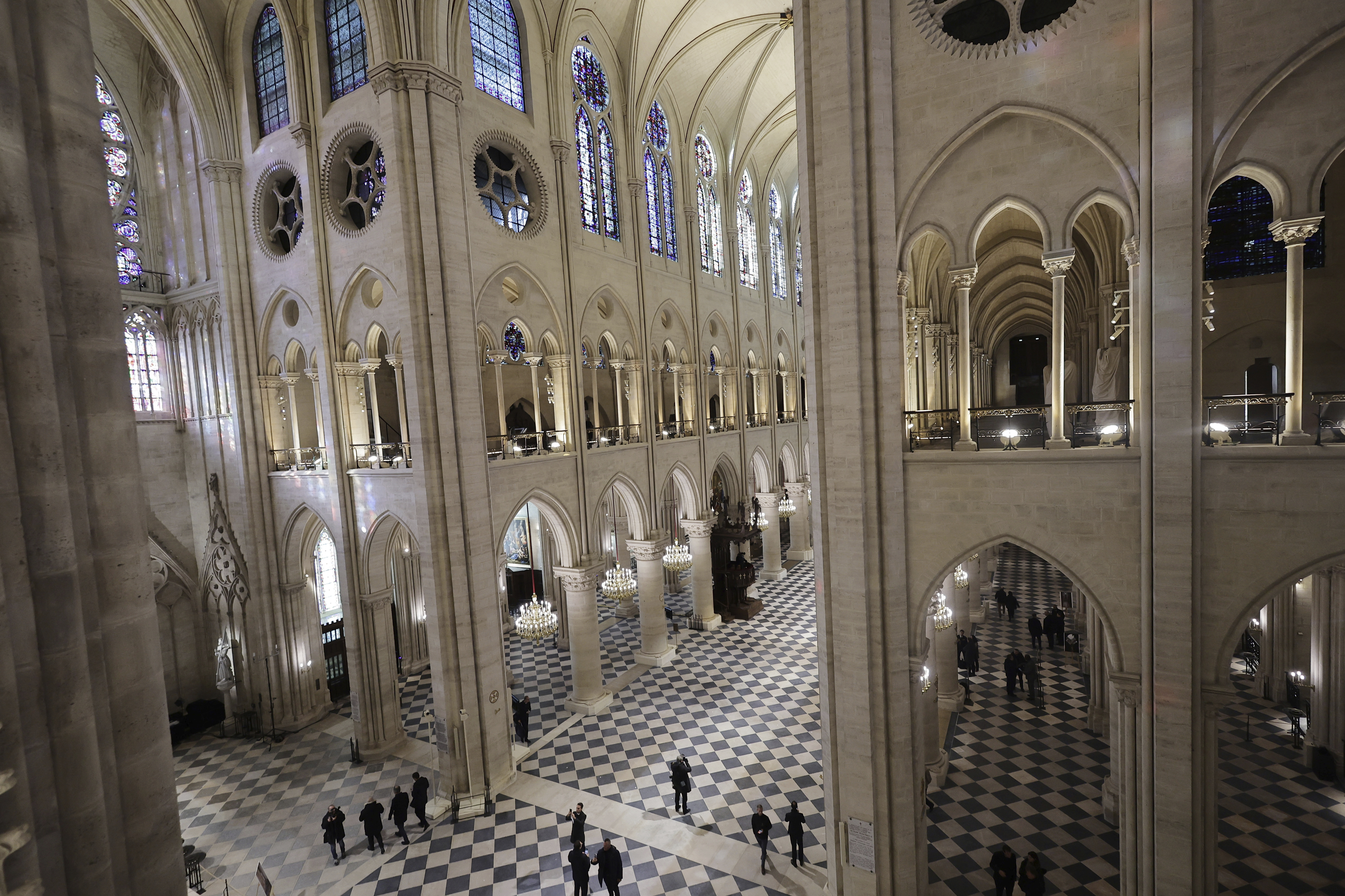 On right: People stroll in Notre-Dame de Paris cathedral while French President Emmanuel Macron visits the restored interiors of the monument, Friday, Nov. 29, 2024 in Paris.<br /> (Christophe Petit Tesson / AP Photo)