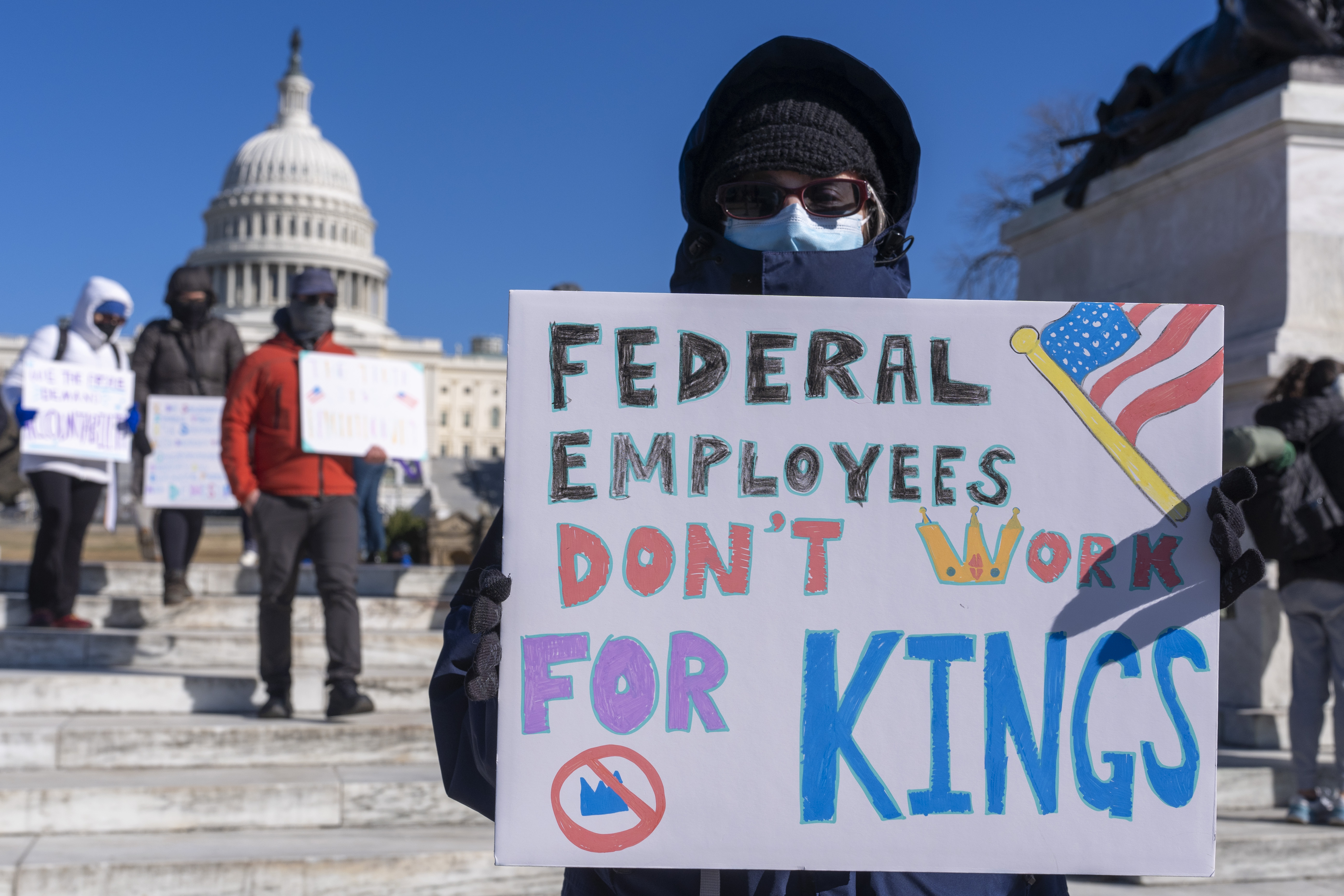 A federal employee, who asked not to use their name for fears over losing their job, protests with a sign saying &quot;Federal Employees Don&#039;t Work for Kings&quot; during the &quot;No Kings Day&quot; protest on Presidents Day in Washington, Feb. 17, 2025.<br />(Jacquelyn Martin / AP Photo)