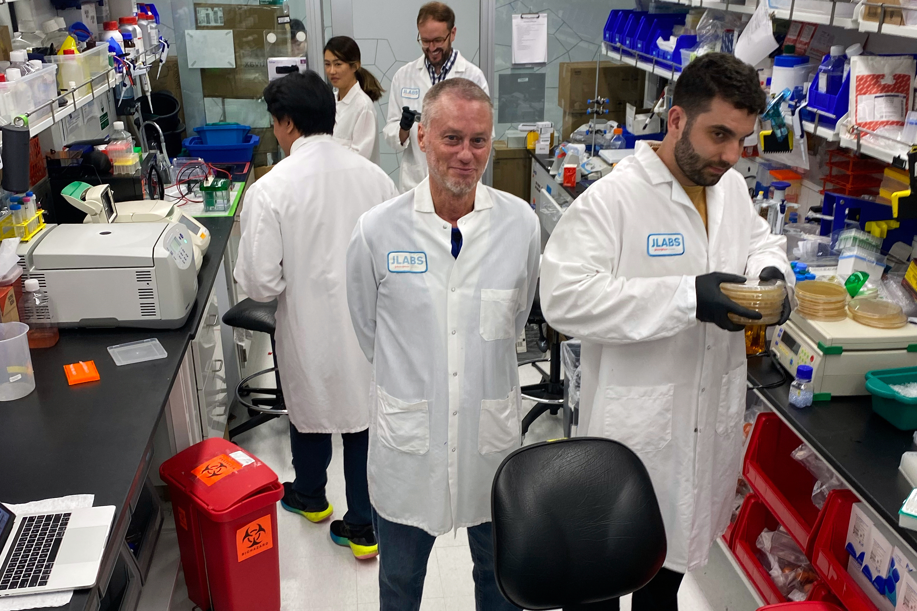 In this photo provided by Centivax, Tim Friede (center)stands in a lab in South San Francisco, Calif., in 2023, that is using his blood to prepare an antivenom to the bites of various snakes.<br />(Centivax via AP)