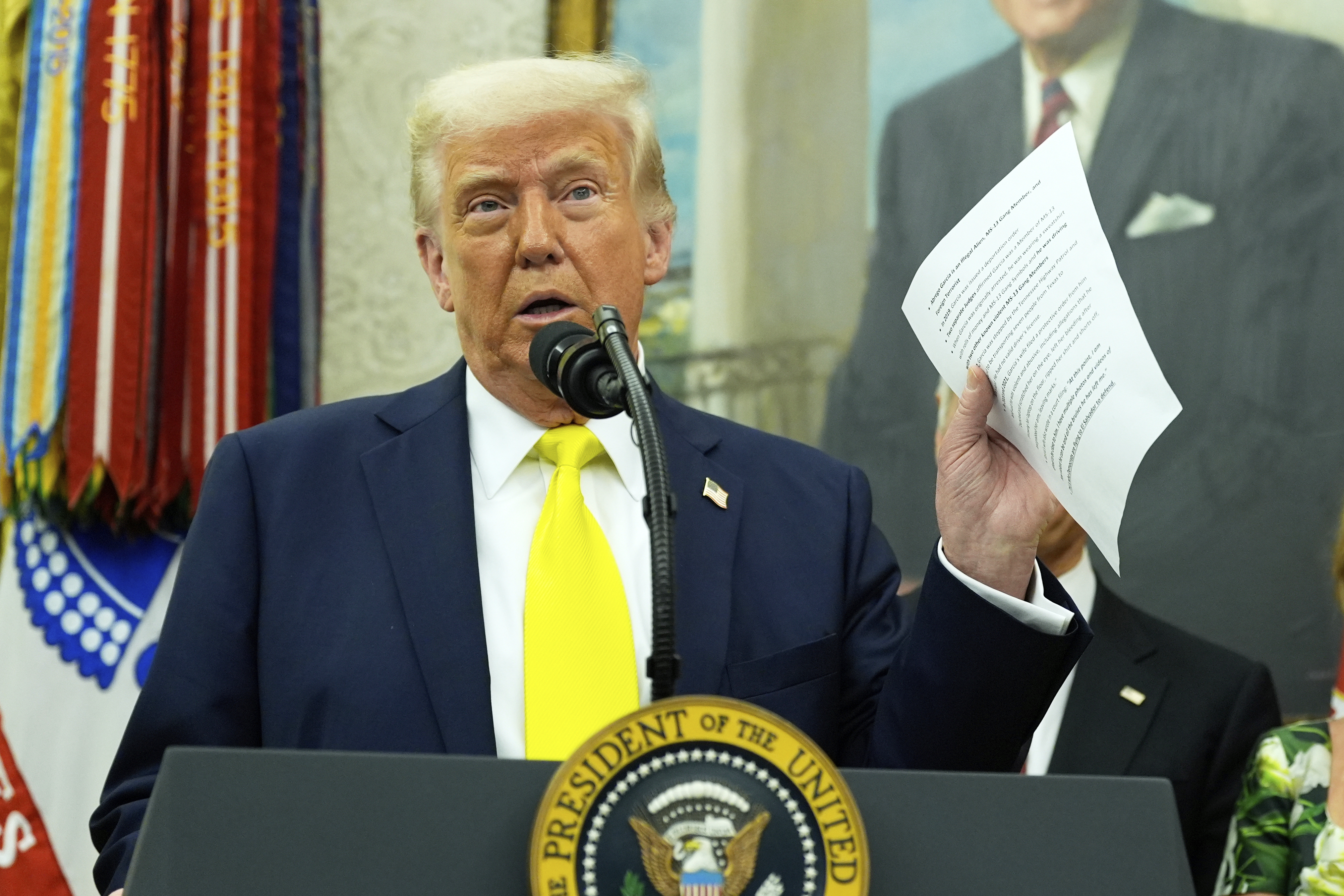 President Donald Trump holds a document with notes about Kilmar Abrego Garcia as he speaks with reporters in the Oval Office of the White House, April 18, 2025, in Washington.<br />(Alex Brandon / AP Photo)