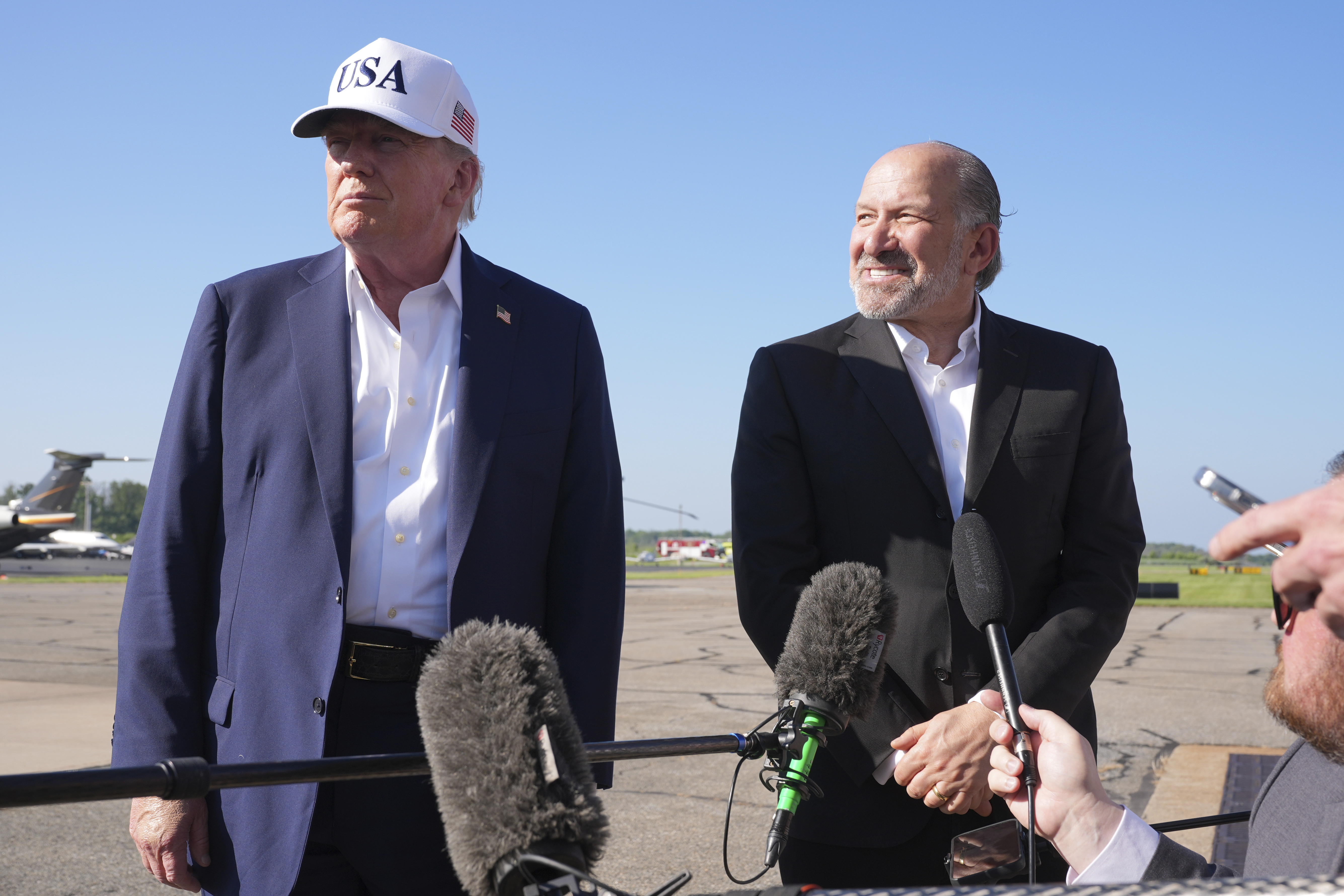 President Donald Trump (left) listens as Commerce Secretary Howard Lutnick speaks with reporters before boarding Air Force One at Morristown Municipal Airport in Morristown, N.J., Sunday, July 6, 2025, en route to Washington.<br />(Jacquelyn Martin / AP Photo)