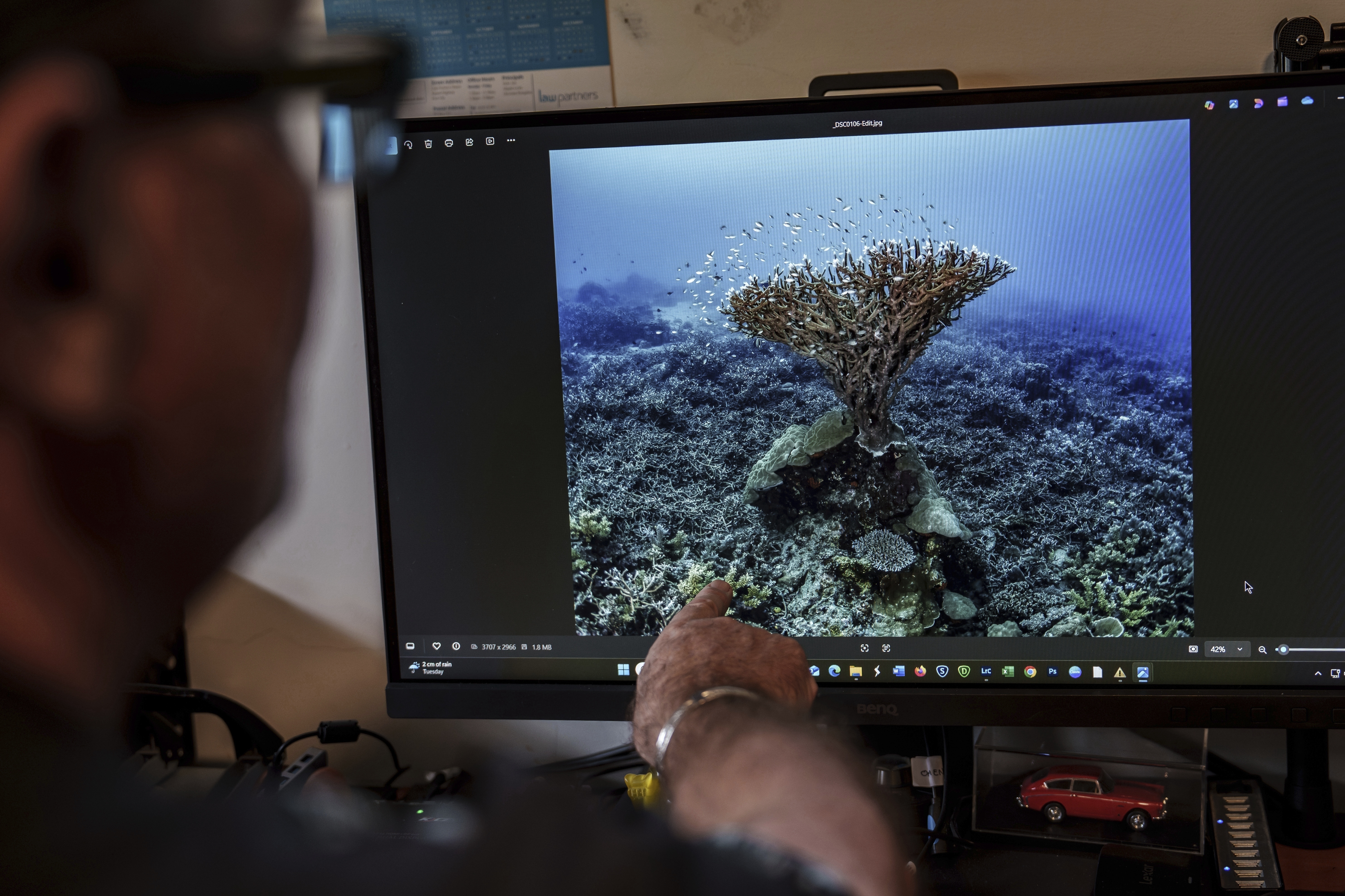 John Warmington points to a photo he took in 2017 of a coral formation at Havannah Harbour, off the coast of Efate Island, Vanuatu, that he once called the &quot;Tree of Life,&quot; on Sunday, July 20, 2025. It was toppled by cyclones in 2023 and further damaged by an earthquake in 2024. (Annika Hammerschlag / AP Photo)