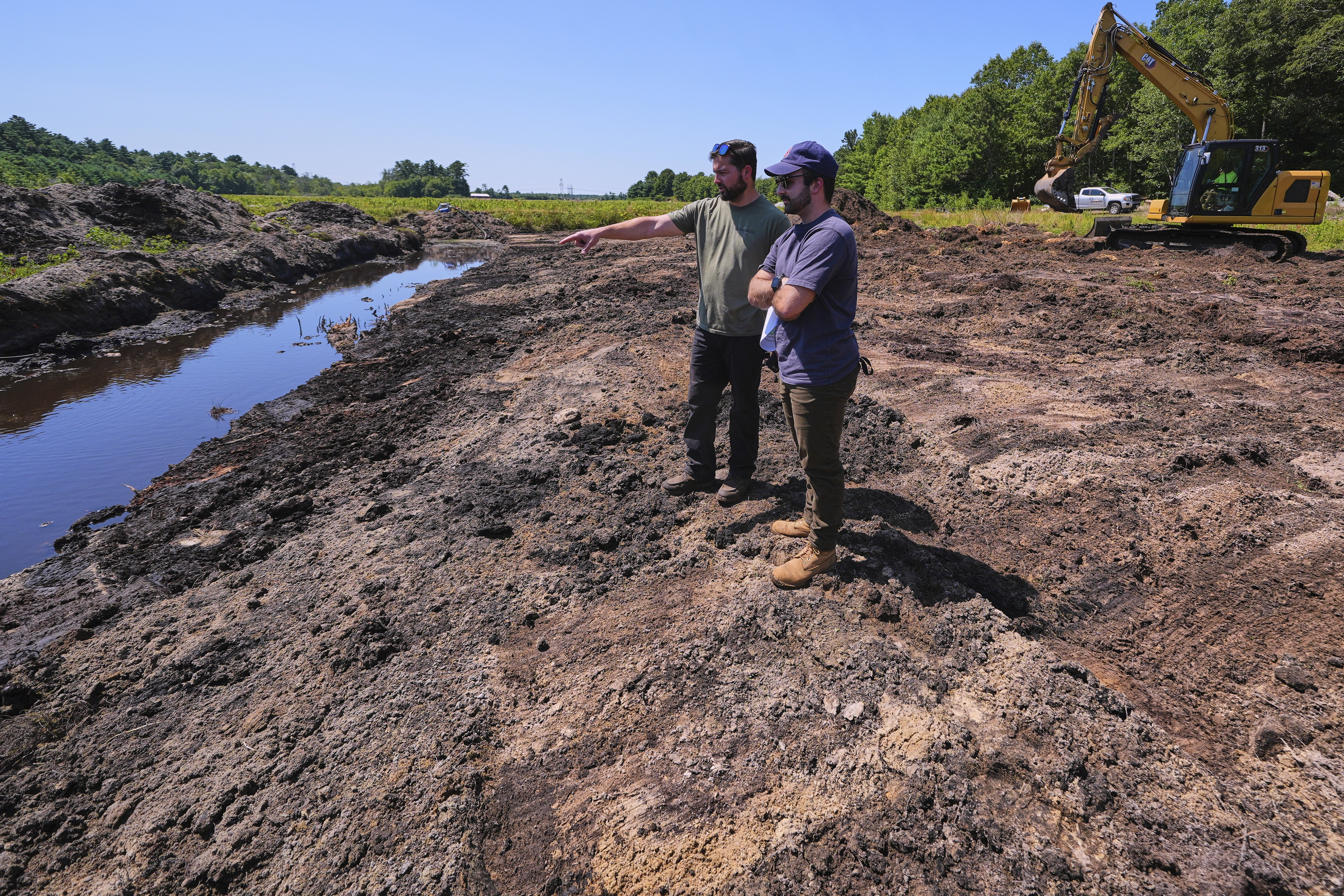 Cranberry grower Jarrod Rhodes points out to engineer Robert Kennedy (right) the path of water flow at a cranberry bog being restored to a natural habitat at the South Meadow Bogs, Thursday, Aug. 7, 2025, in Carver, Mass.<br />(Charles Krupa / AP Photo)