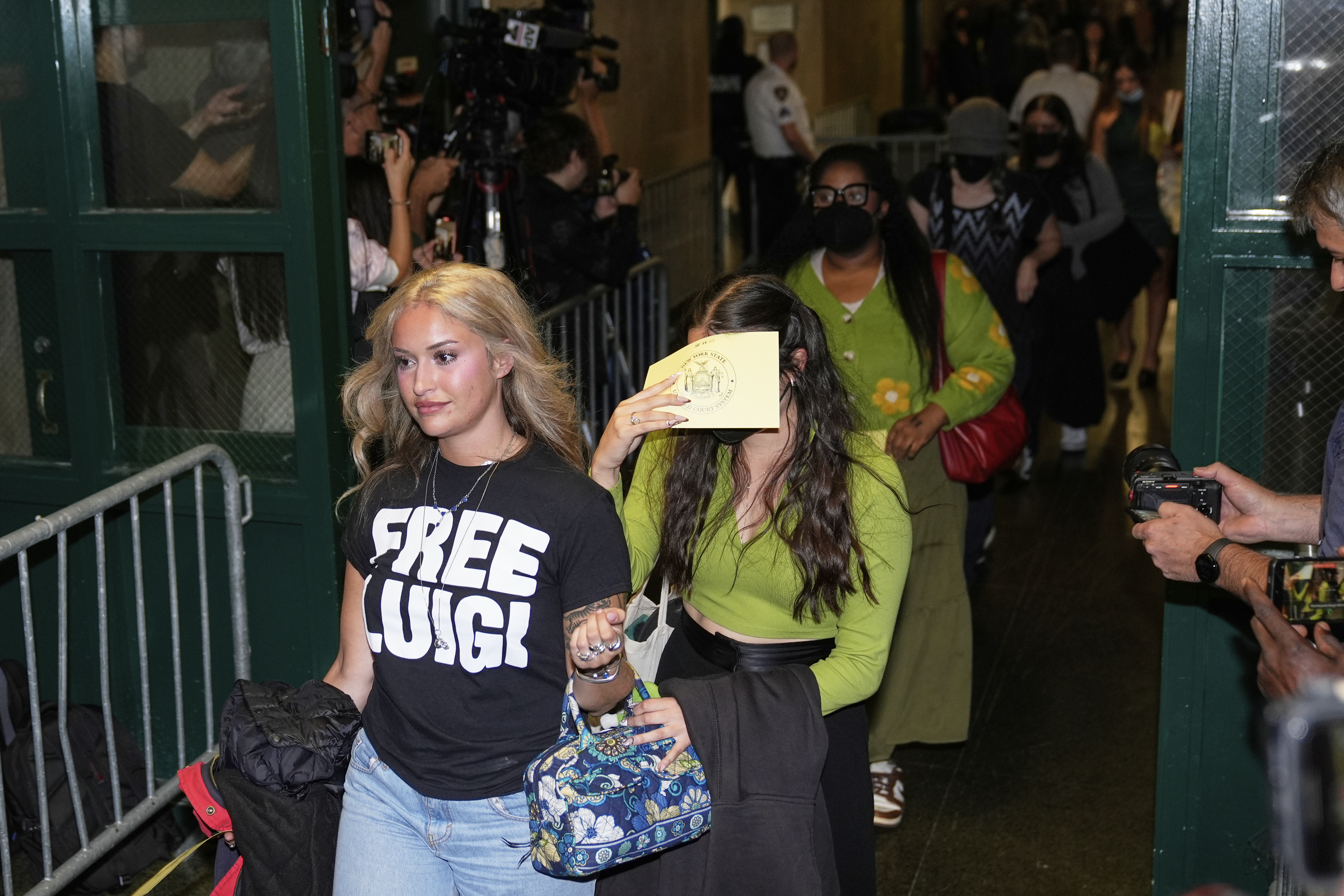 Members of the public, including a woman wearing a &quot;Free Luigi&quot; shirt, enter a courtroom before Luigi Mangione is escorted into the courtroom in New York, Tuesday, Sept. 16, 2025.<br />(Seth Wenig / AP Photo)