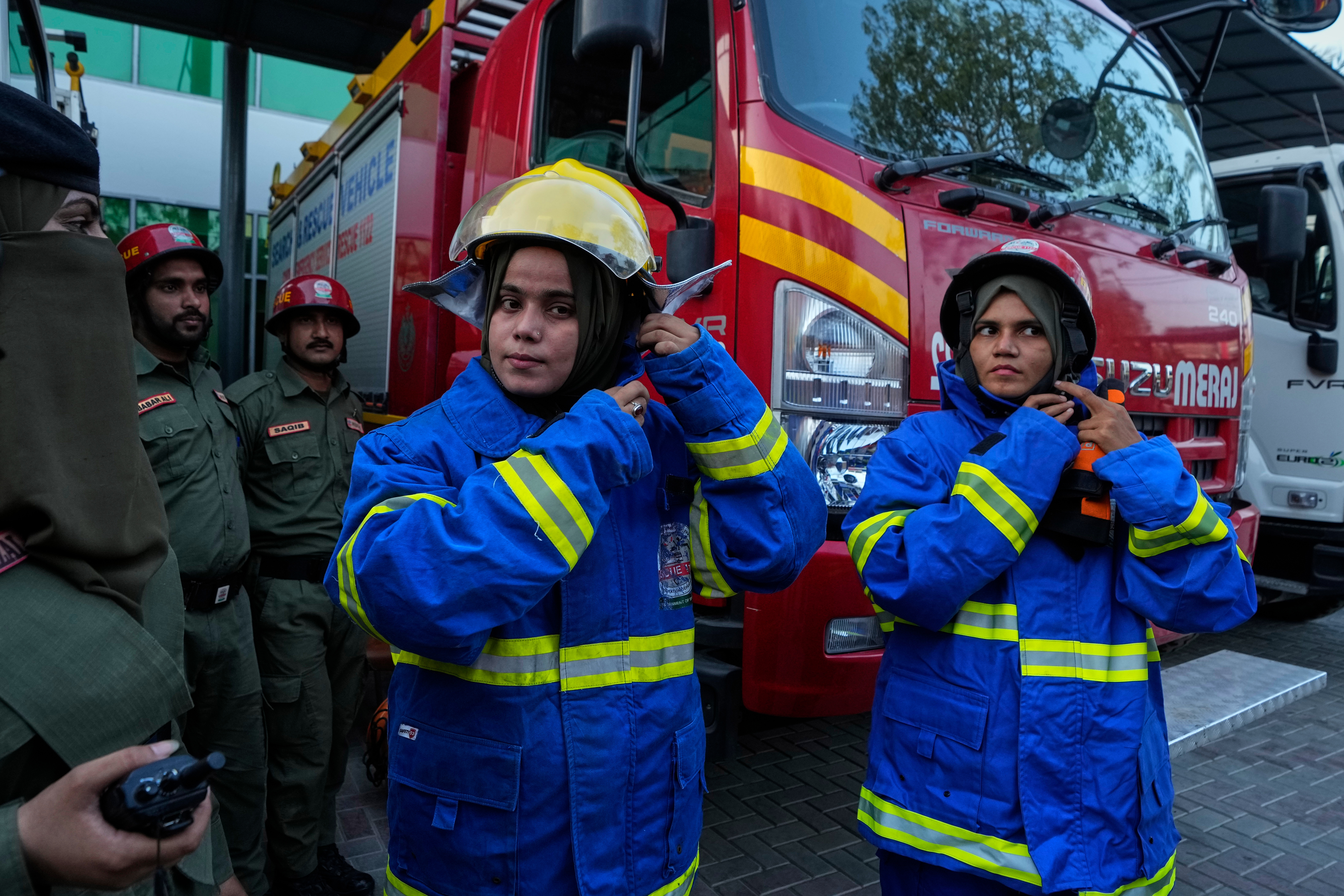 Female firefighter Syeda Masooma Zaidi (center) prepares with her team members to attend a routine training session, at the compound of their office in Karachi, Pakistan, Friday, Oct. 10, 2025.<br />(Fareed Khan / AP Photo)