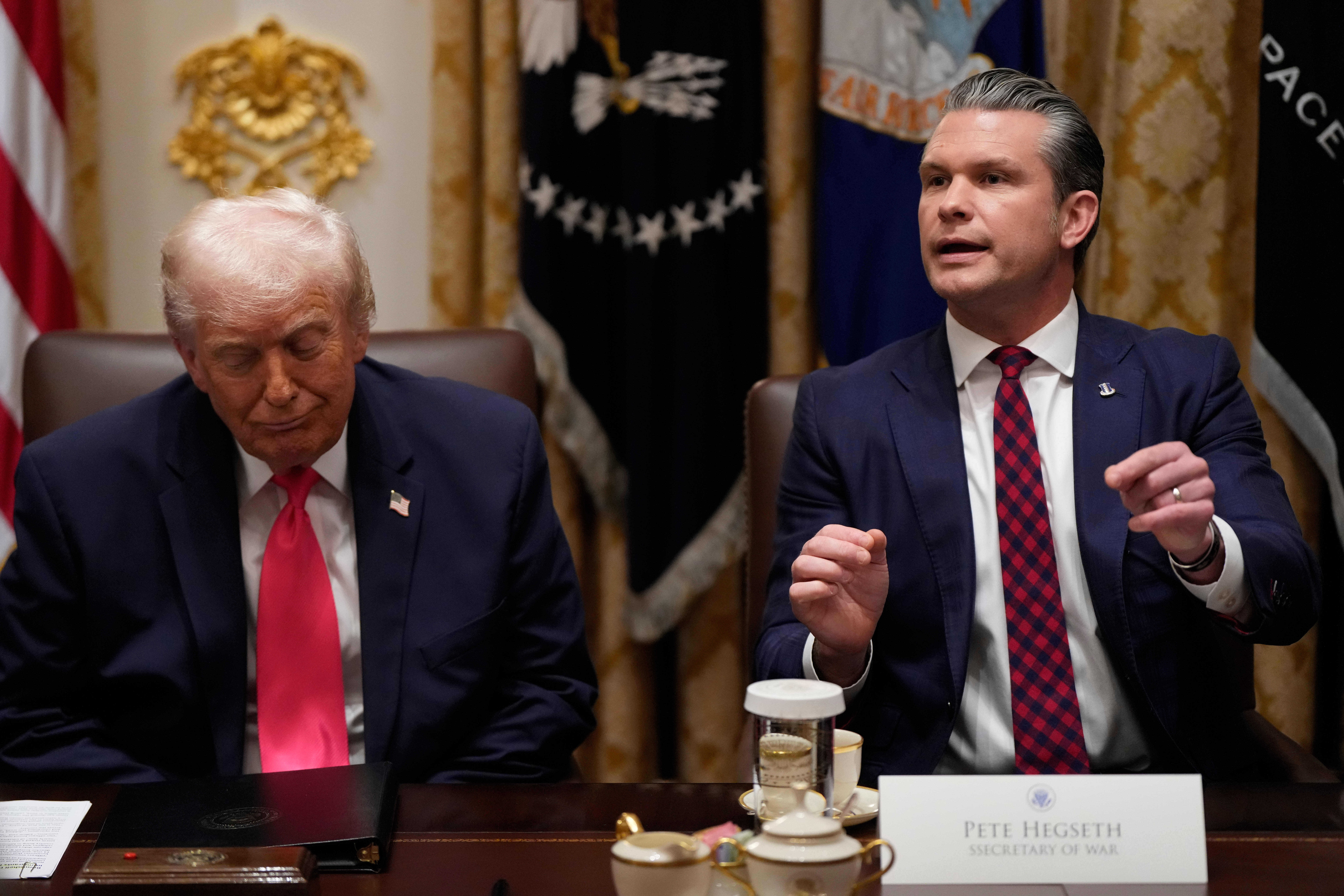 Defense Secretary Pete Hegseth speaks as President Donald Trump looks on, during a Cabinet meeting at the White House, Tuesday, Dec. 2, 2025, in Washington.<br /> (Julia Demaree Nikhinson / AP Photo)