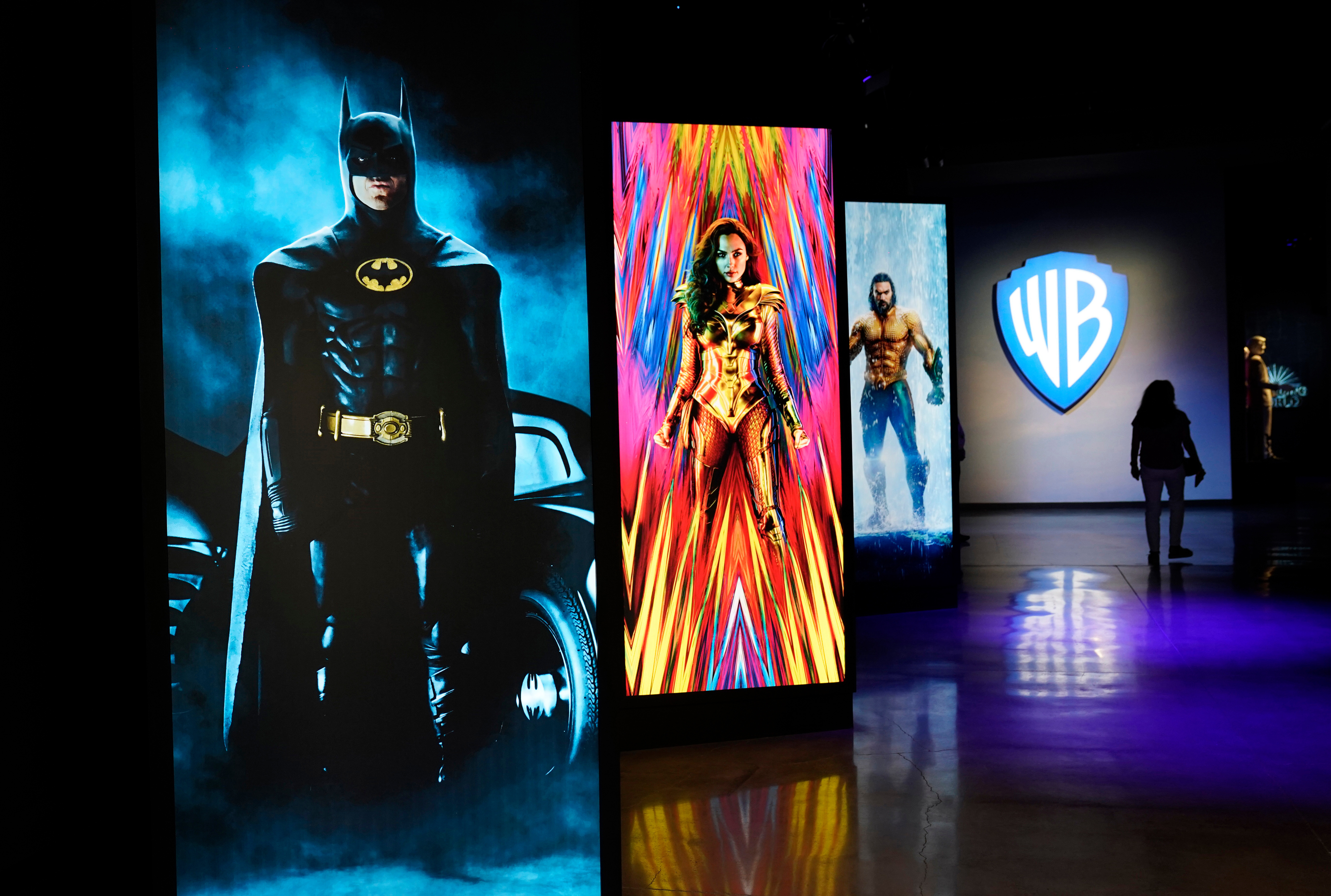 A visitor walks past portraits of DC Comics superheroes as she enters the &quot;Action and Magic Made Here&quot; interactive experience at the Warner Bros. Studio Tour Hollywood media preview on June 24, 2021, in Burbank, Calif.<br />(Chris Pizzello / AP Photo)