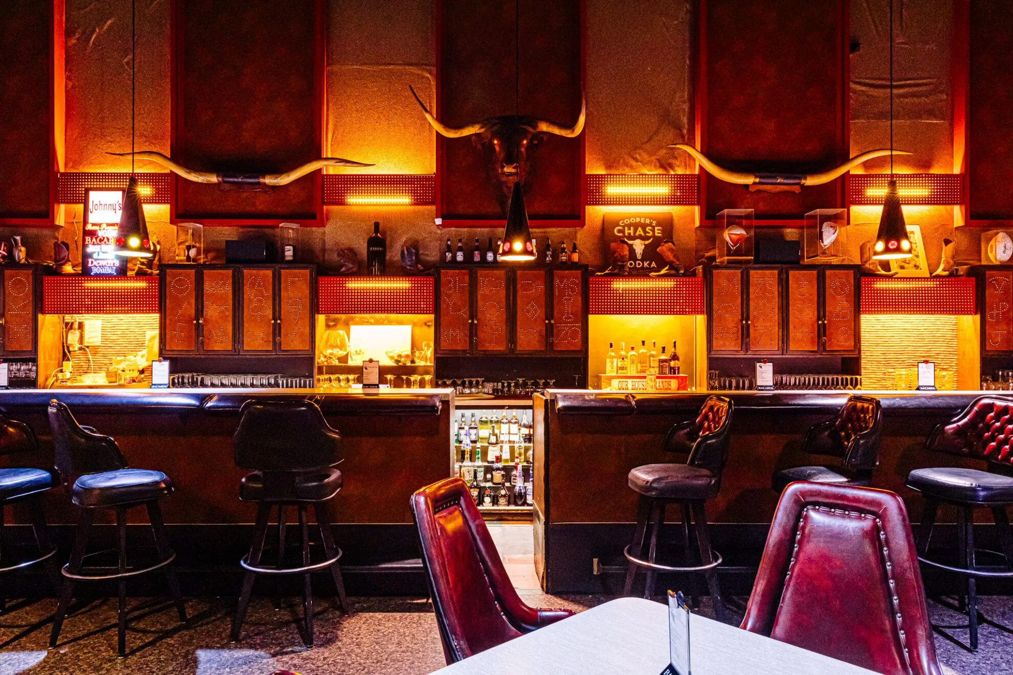 The iconic bull with glowing red eyes is a staple of the restaurant’s charismatic bar, decorated with antiques, local art and a handful of chairs made from vintage saddles.<br />(Joshua Foo / Flatwater Free Press)