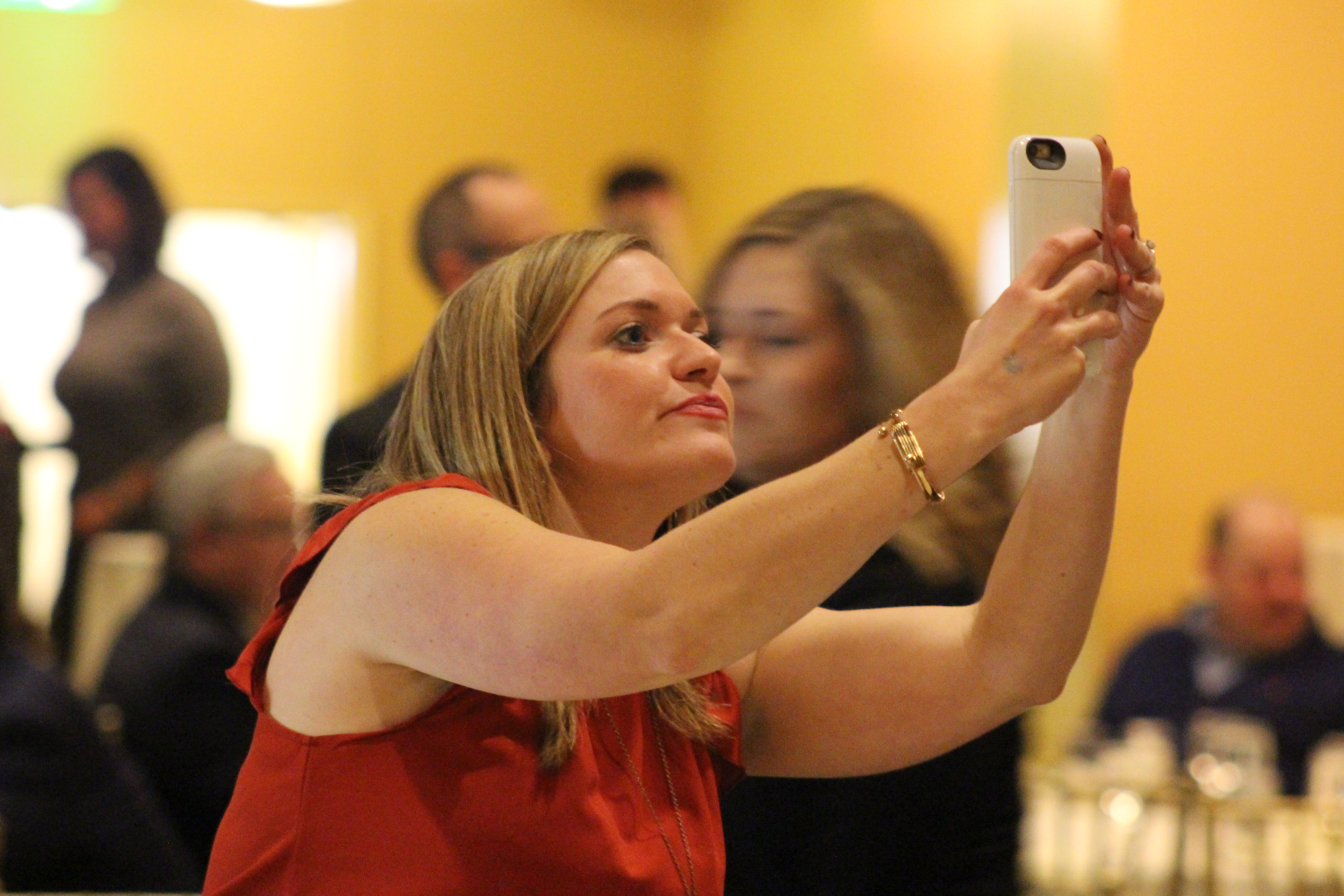 Christine Mori of the Douglas County Public Defender’s Office snaps a photo before the start of the Barristers’ Club Christmas show at the Paxton Ballroom, 1403 Farnam St., on Dec. 12, 2019. (Photo by Scott Stewart)