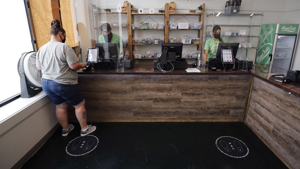Kerri Thibodeau of Stoughton, Mass., makes a purchase at Pure Oasis, a Black-owned recreational marijuana dispensary in the Grove Hall neighborhood of Boston on June 24, 2020. (AP)