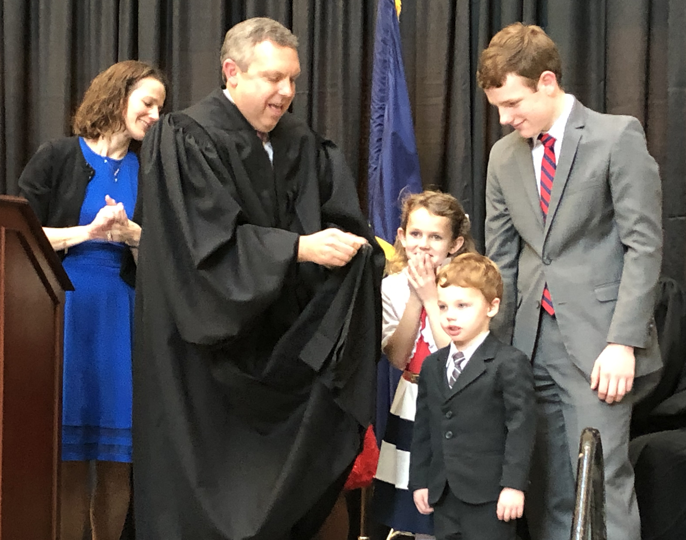 Brian C. Buescher dons his black robes with the help of his family during his investiture ceremony at the Hruska Federal Courthouse on Friday, Nov. 15, 2019. (Photo by Scott Stewart)