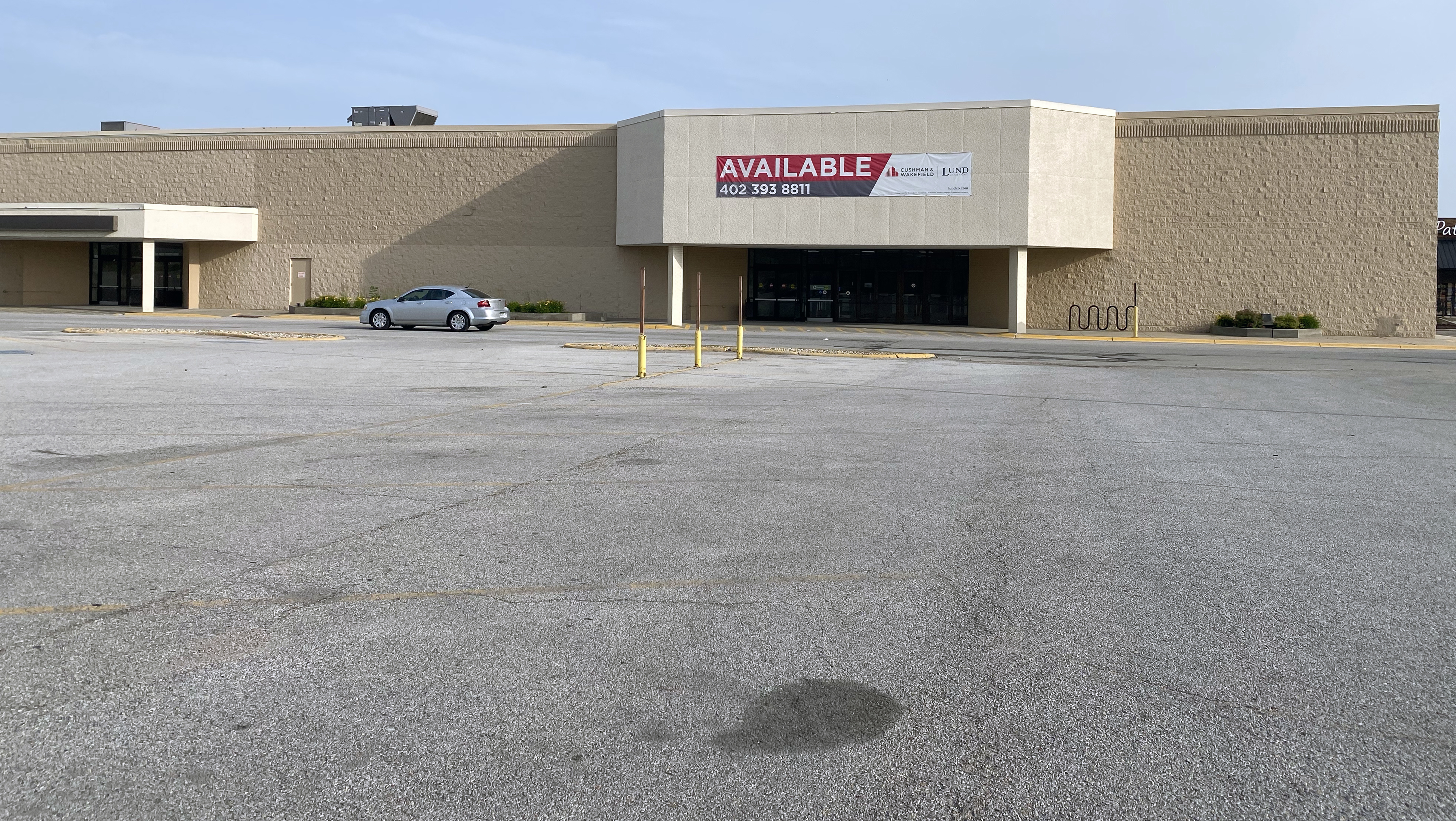 Above, a car drives by a former Shopko store at 14445 W. Center Road that is listed for sale Sunday, June 28, 2020. Across the country, such signs are expected to be seen more frequently as the real estate industry struggles. (Scott Stewart)