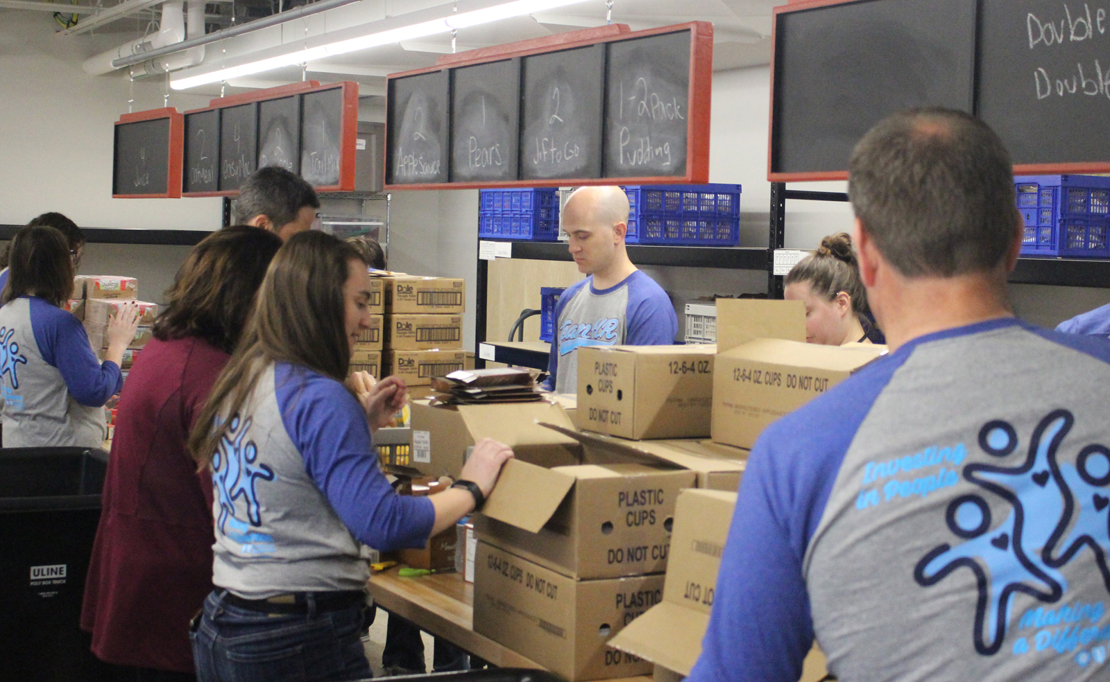 Volunteers unload food from Hy-Vee to prepare for the Completely KIDS weekend backpack program at the nonprofit’s headquarters, 2566 St. Mary’s Ave., on Tuesday, May 15, 2019. (Photo by Scott Stewart)