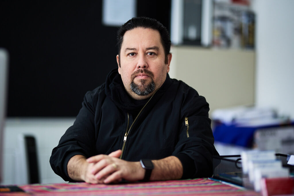 Juan Carlos Garcia in an office at Omaha Welcomes the Stranger, a shelter for recently arrived asylum-seeking families.<br />(Joseph Saaid / Flatwater Free Press)