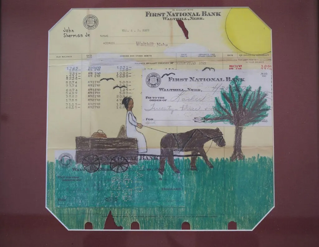 A framed bank statement, turned into artwork done by students at the nearby Omaha Nation Public Schools, now hanging in the Dr. Susan La Flesche Picotte Center in Walthill.<br />(Jerry L Mennenga / Flatwater Free Press)