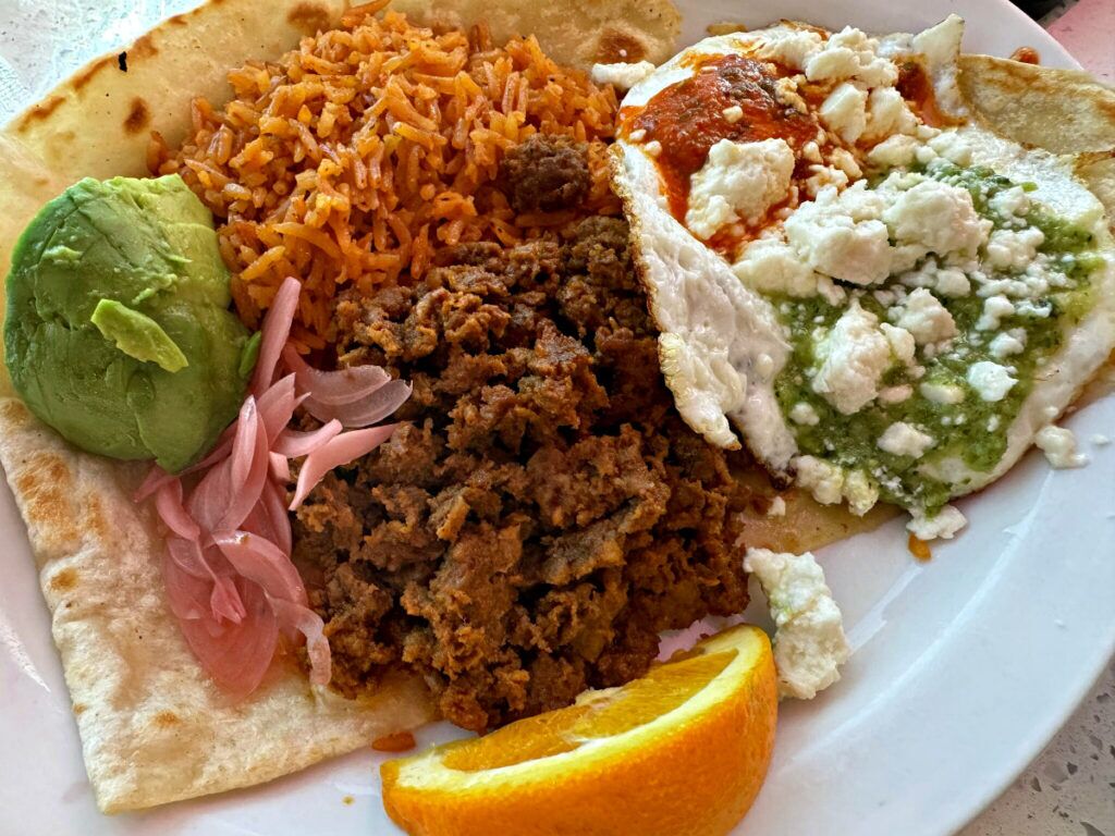 A classic take on a Mexican breakfast, the dish comes with two eggs cooked to the diner’s liking along with Mexican rice, avocado, two salsas, queso fresco cheese, chorizo and flour tortillas.<br />(Sarah Baker Hansen / Flatwater Free Press