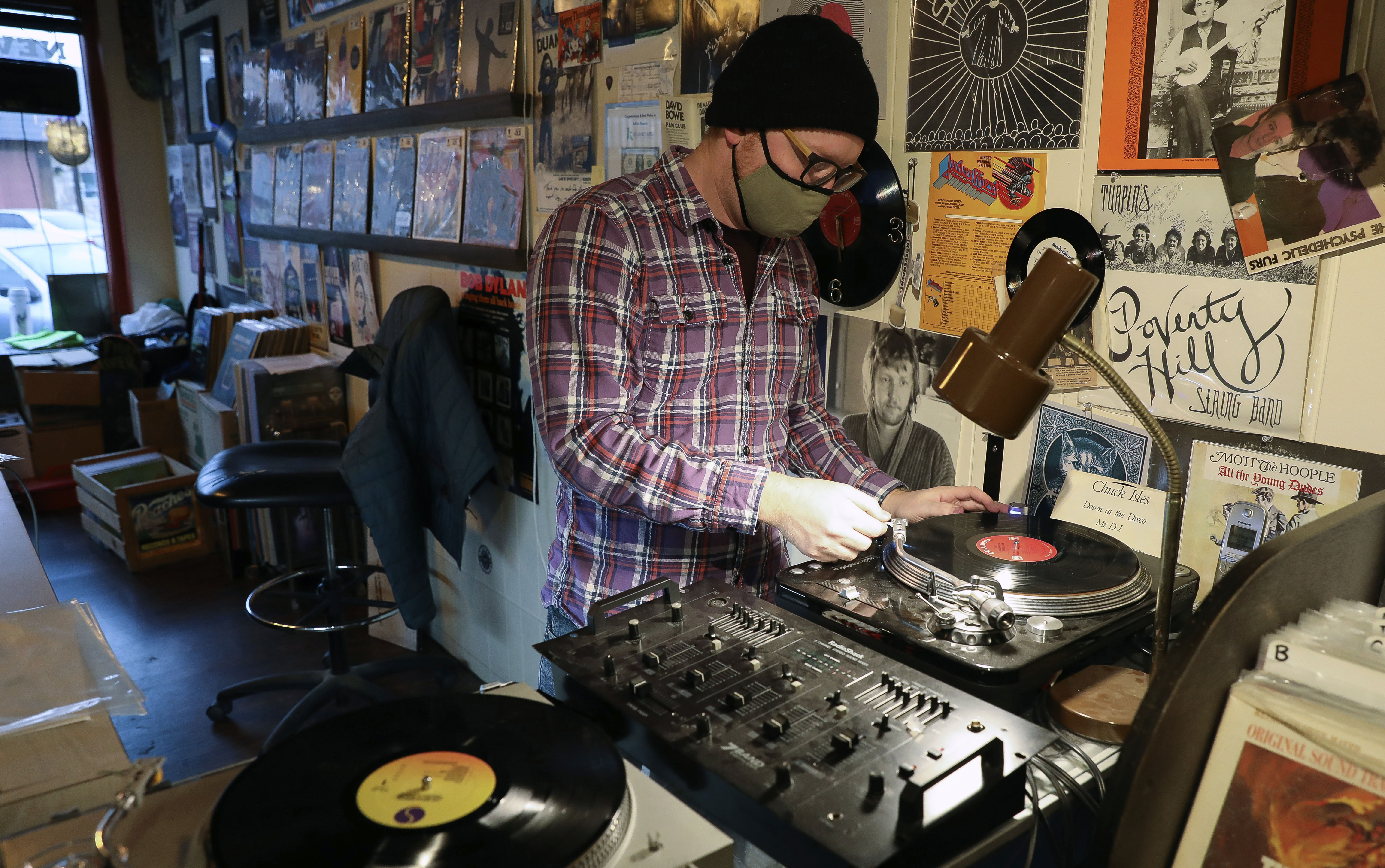Buffalo Records volunteer Jacob Rosdail puts a record on the turntable Wednesday, Oct. 21, 2020 at the record store in Kearney. (Ericka Pritchard/Kearney Hub via AP)