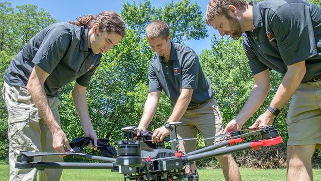 From left, Evan Beachly, Jim Higgins and Carrick Detweiler assemble a drone system before taking it for a test flight. The system features a software application that makes it easy to operate. It can also be flown at night, helping crews safely fight fires despite limited visibility. (Courtesy Alyssa Amen/NUtech Ventures/UNL)