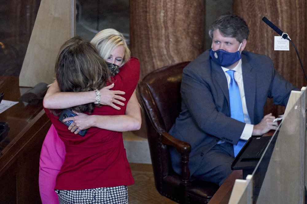 State Sen. Suzanne Geist of Lincoln, left, is hugged by Sen. Julie Slama of Peru as Sen. Mike Hilgers of Lincoln watches, following the passage of LB 814, Geist’s bill to prohibit the dilation and evacuation procedure during an abortion, in Lincoln, Thursday, Aug. 13, 2020, on the last day of a legislative session marked by major disruptions from the coronavirus and political feuds that often turned personal. (AP)