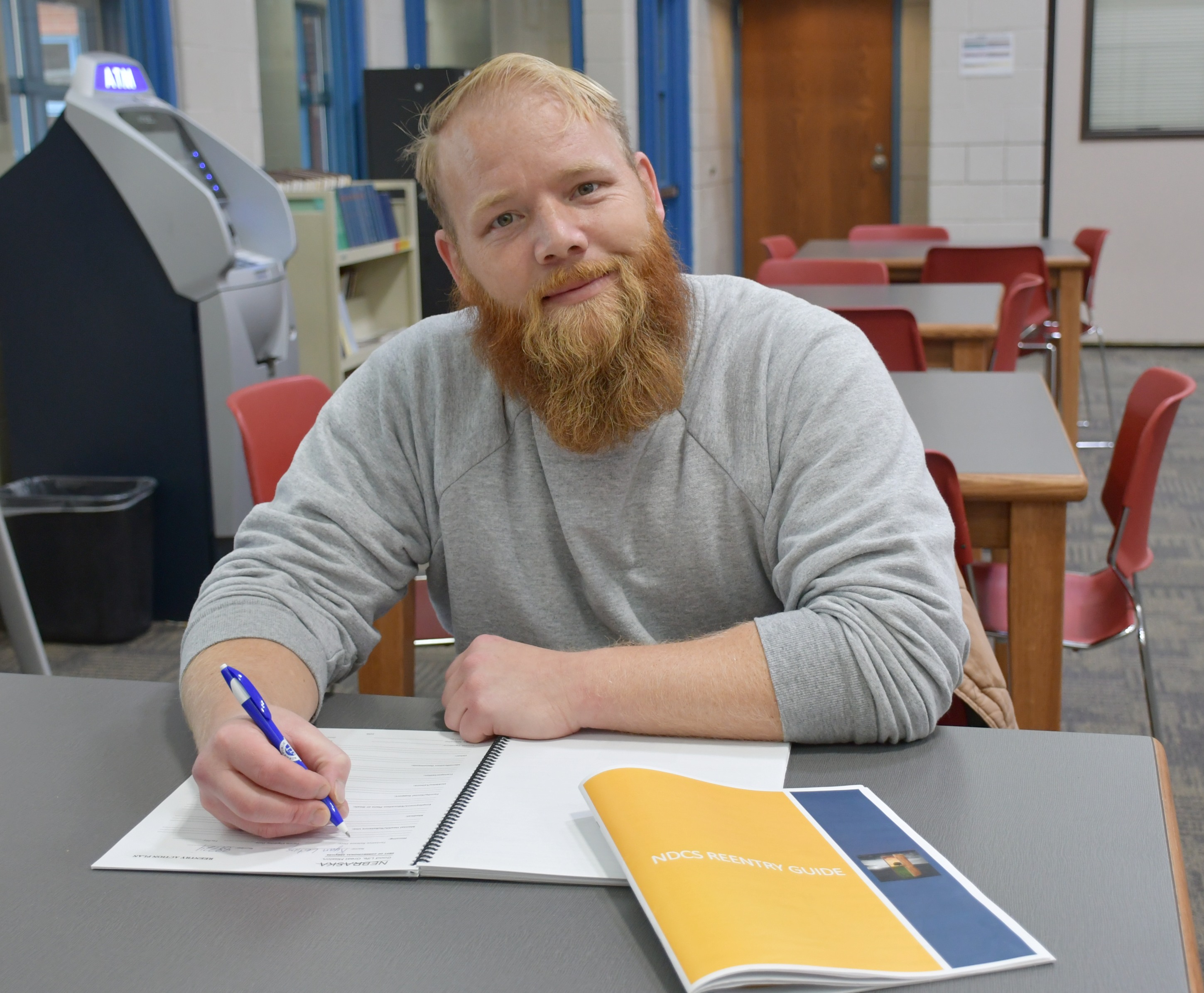 Ryan Leiting writes in a workbook at Community Corrections Center-Lincoln. “Reentry gives us hope for the future,” he said. “These guides and workbooks give us that opportunity.” (Courtesy NDCS)