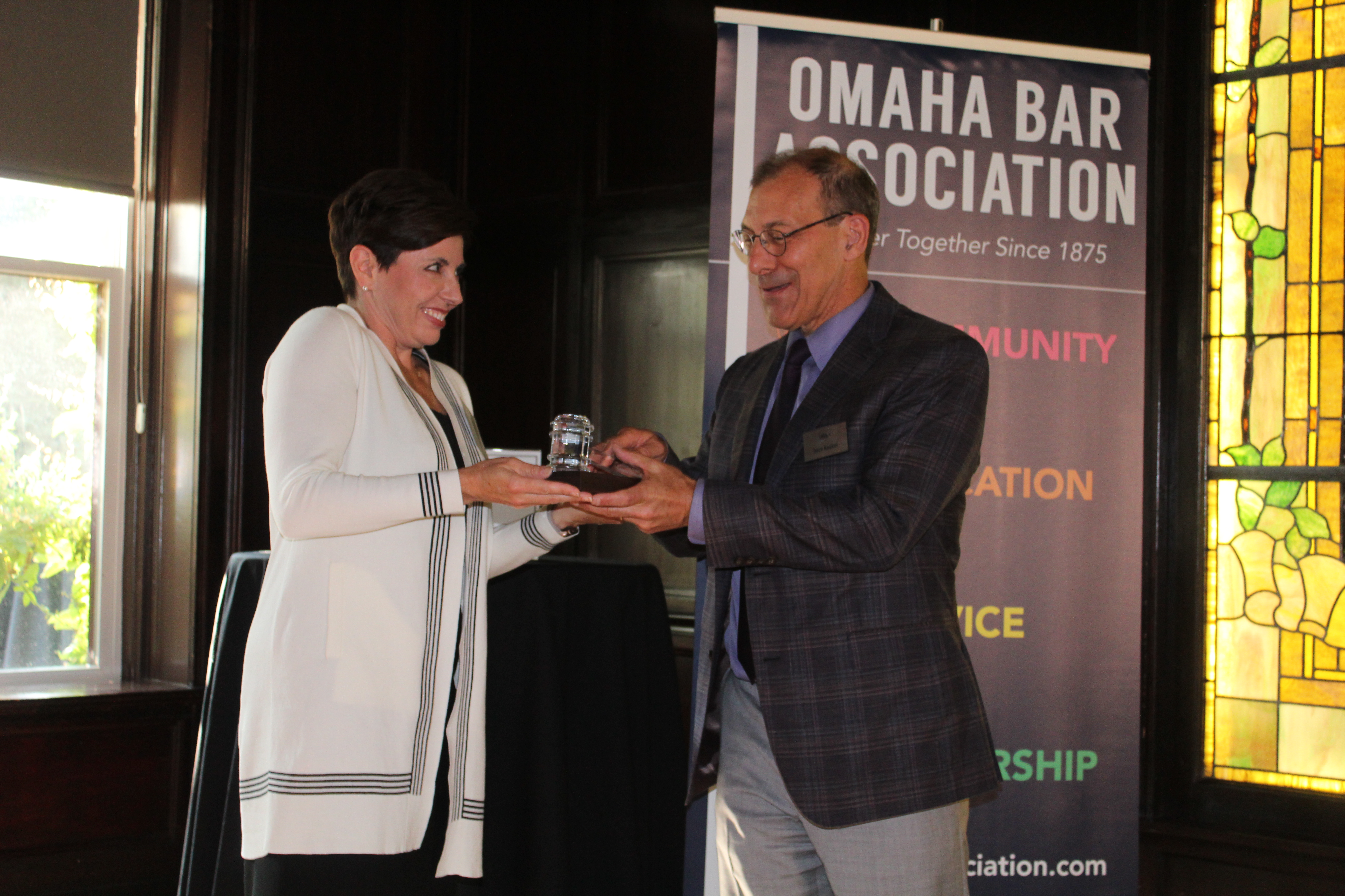 Incoming Omaha Bar Association President Judge Stephanie Hansen, left, presents outgoing OBA President Dave Koukol with a crystal gavel during the OBA President’s Reception at Lucille’s in the Old Market, July 21, 2021. (David Golbitz/Daily Record)