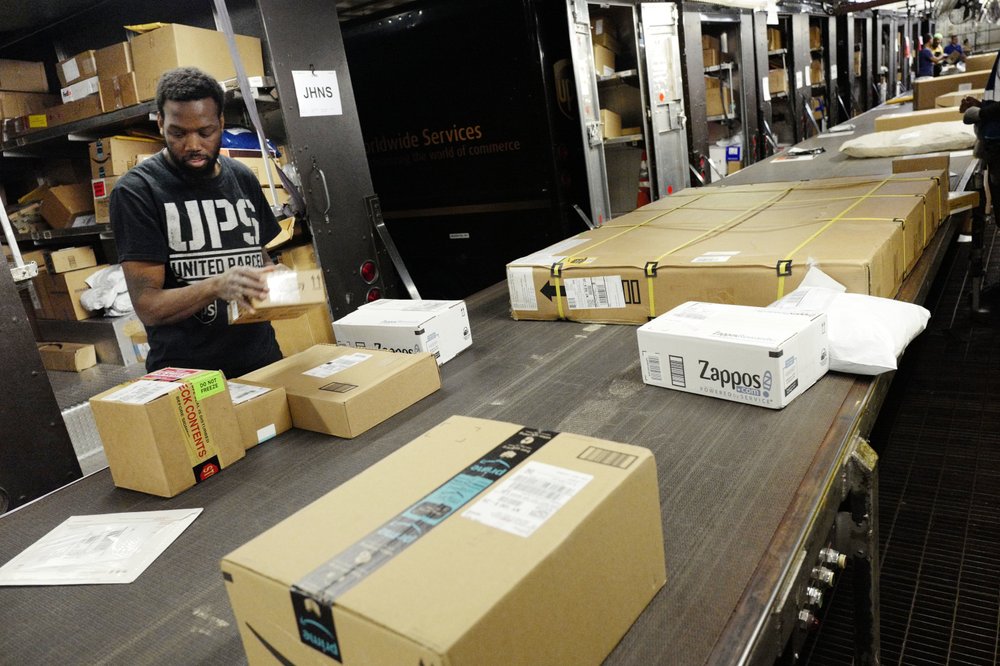 A UPS employee takes packages from a conveyor belt for loading onto a truck at a UPS facility in New York, May 9, 2017. Carriers like FedEx and UPS have been ramping up their holiday hiring while asking store clients to move their shipping volume on lighter days in their network. Stores are also pushing their customers to buy early to smooth out the peaks in the weeks leading up to Christmas. (AP)